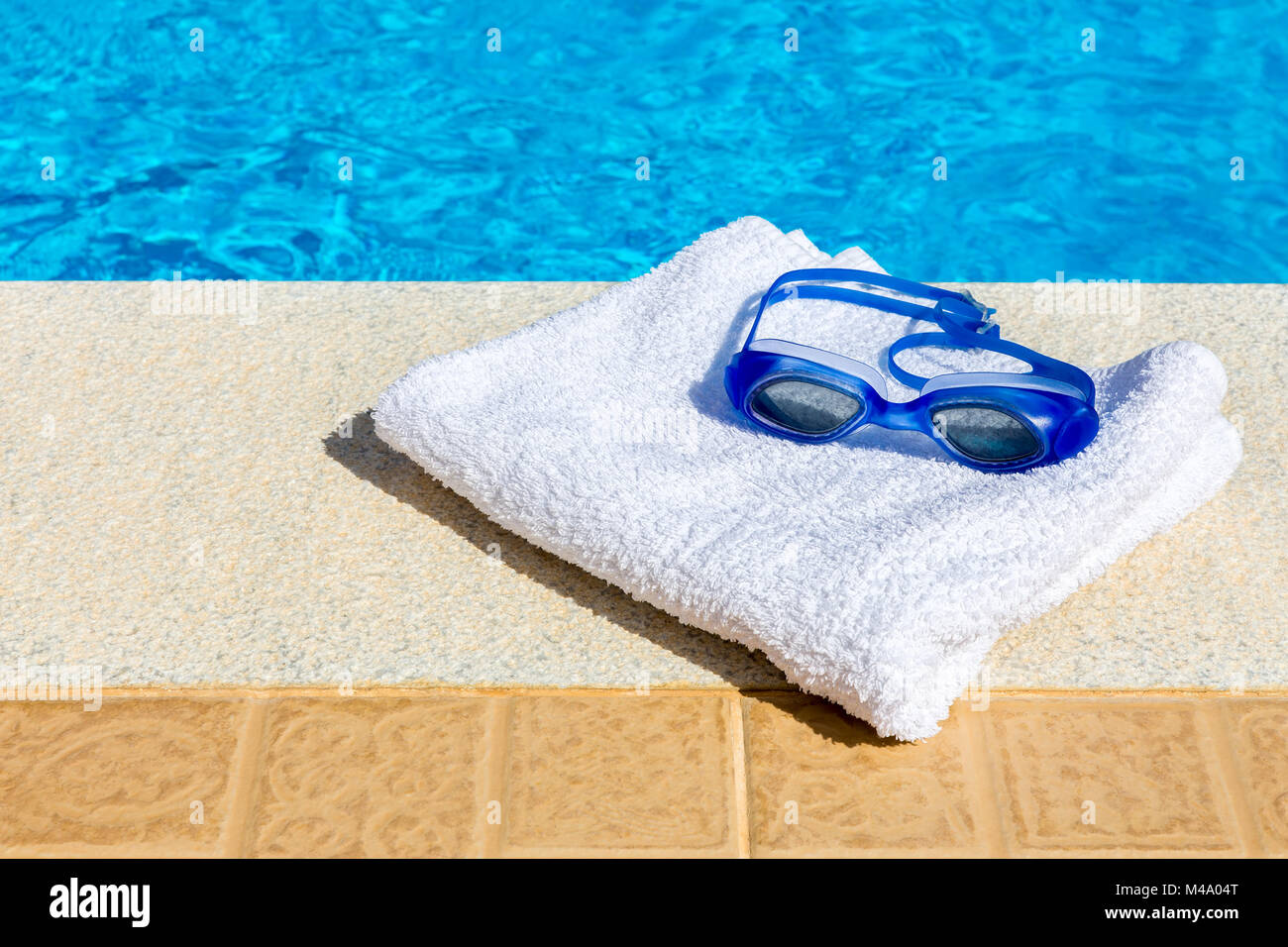 Lunettes de natation et serviette proche piscine Banque D'Images