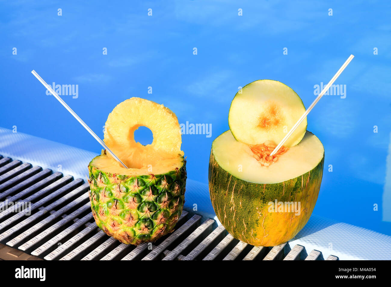 L'ananas et fruits de melon avec des pailles à la piscine Banque D'Images