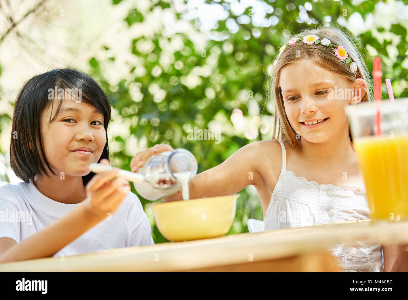 Deux filles manger des céréales et boire du lait pour le petit-déjeuner au camp. Banque D'Images