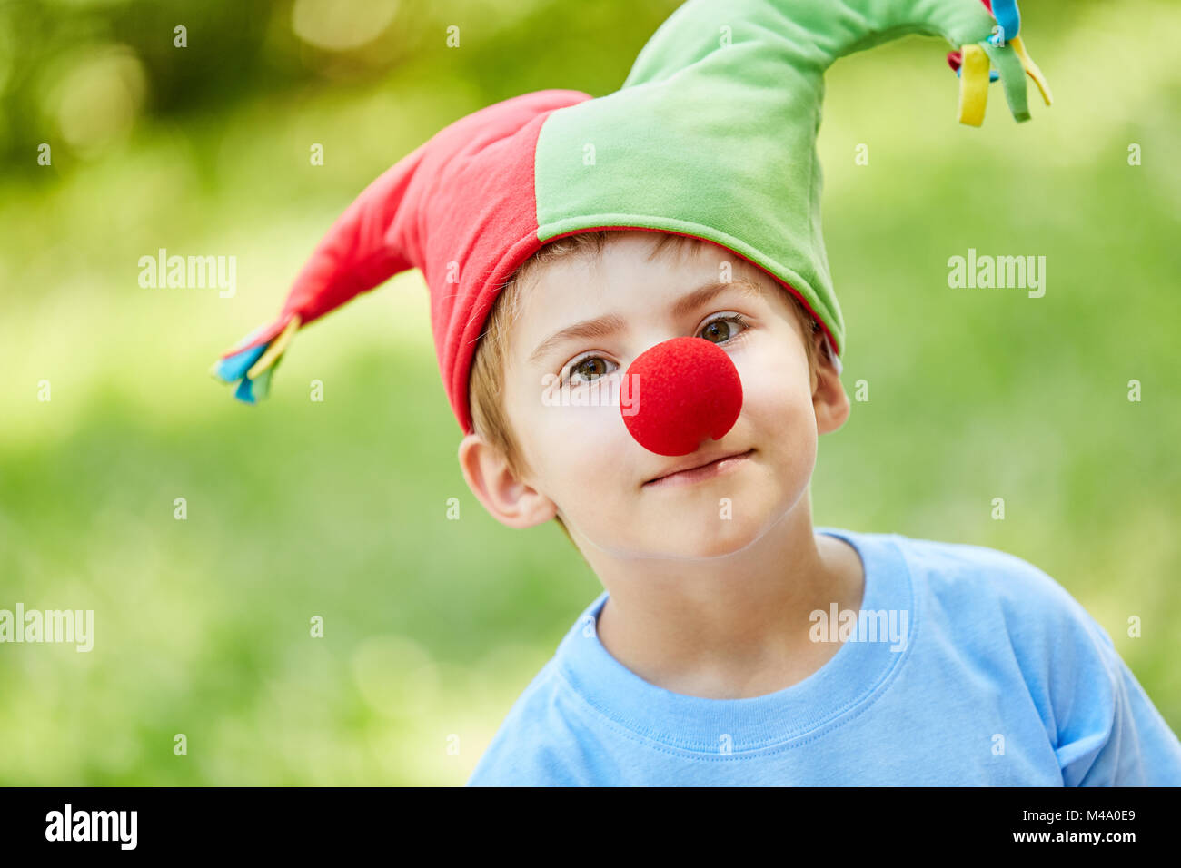 Garçon avec un nez rouge et un marché de cap en Arlequin dans Carnival ou le Carnaval Banque D'Images