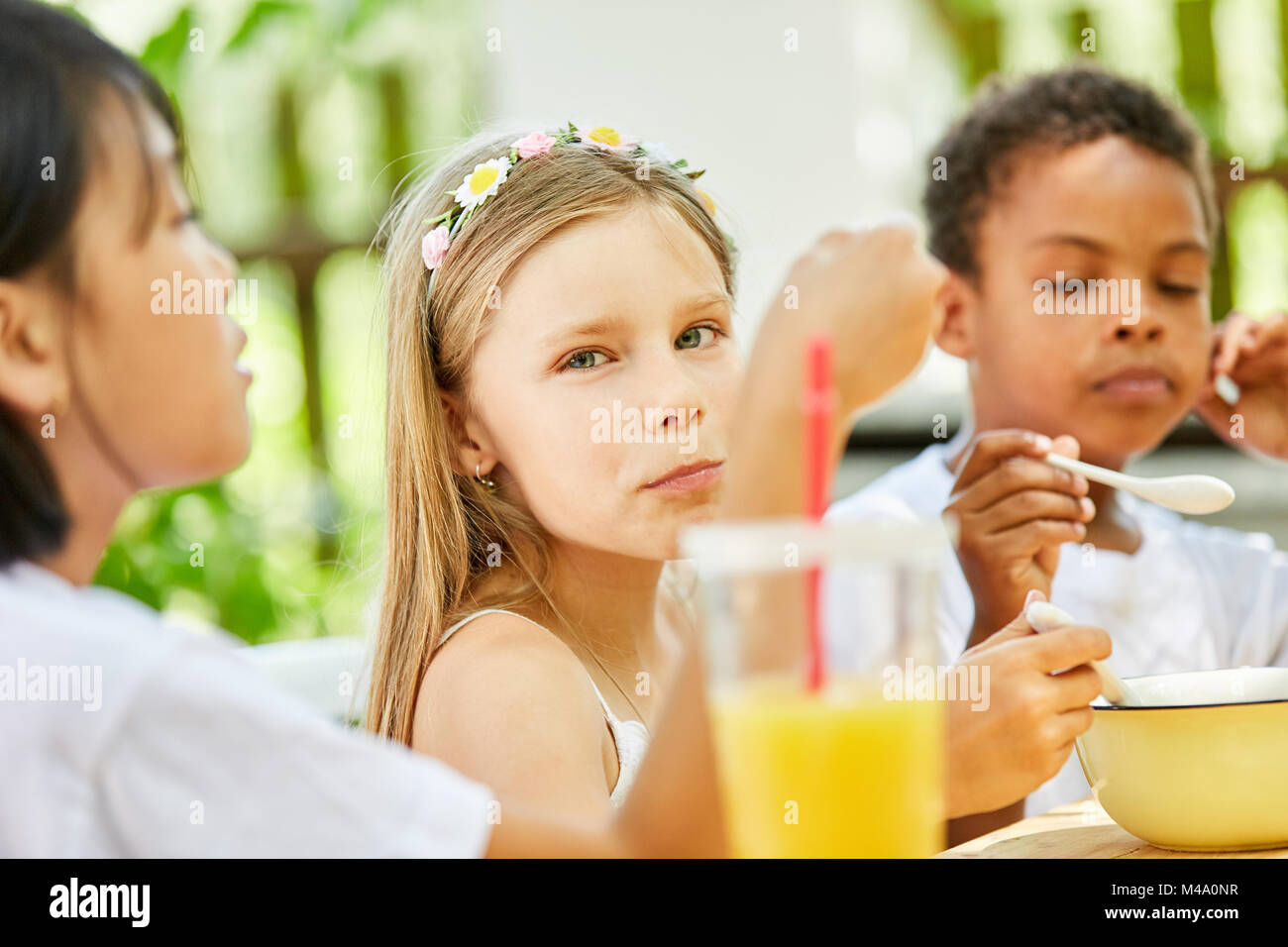 Fille et ses amis de prendre le petit déjeuner ensemble à la maternelle Banque D'Images