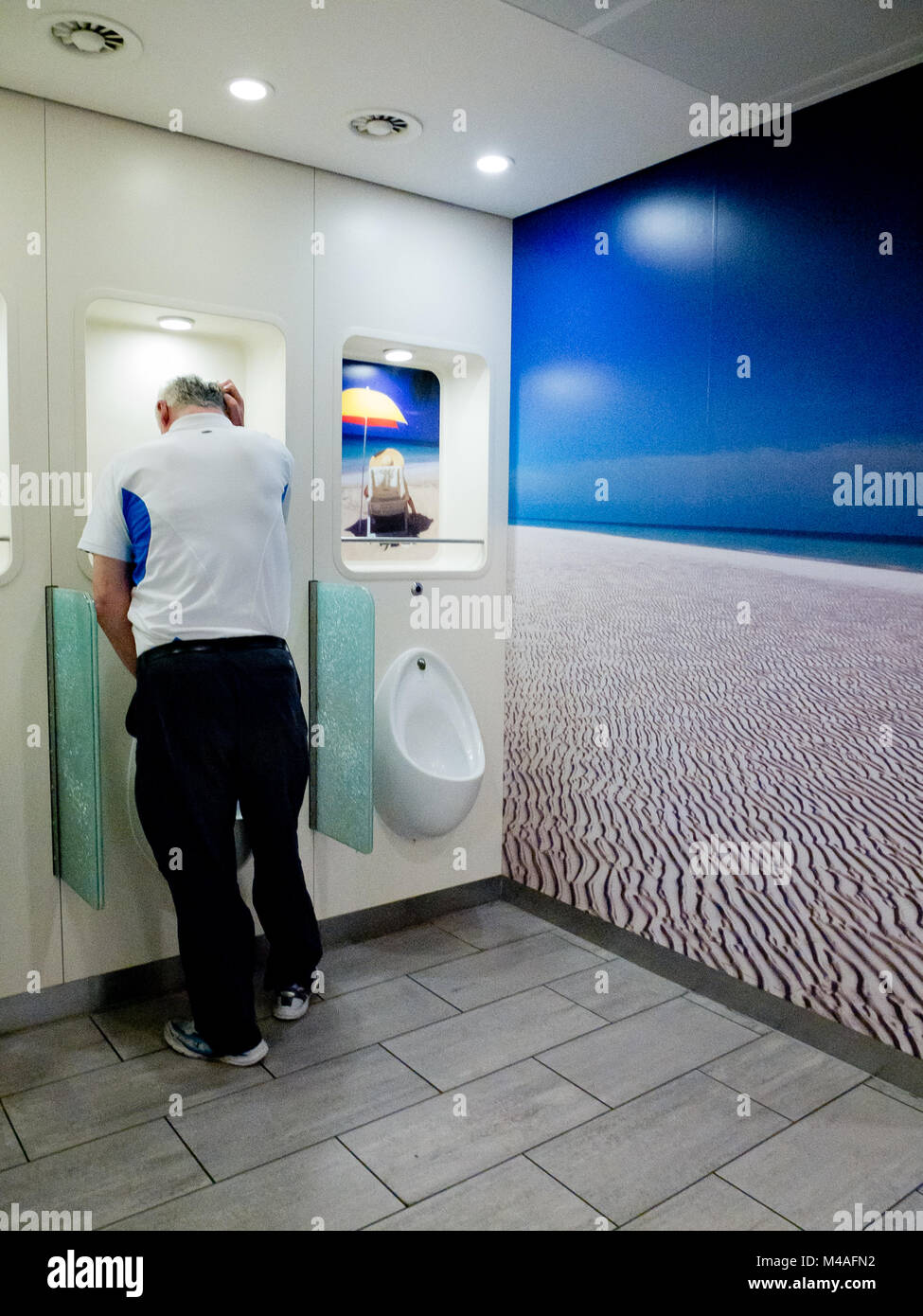 Un homme est en train de se pisser dans les toilettes / pissoir. 2012. Banque D'Images