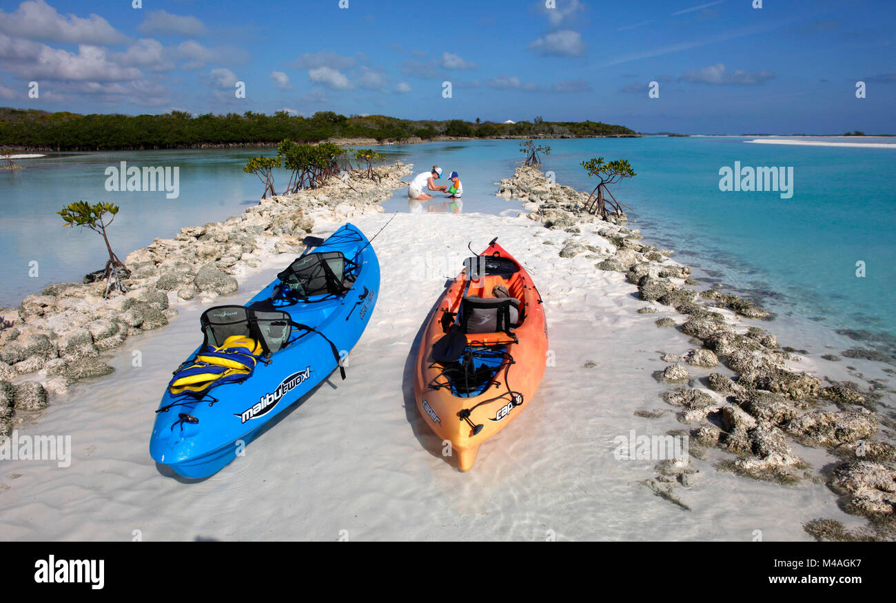 Une mère et son fils jouer dans les eaux peu profondes eaux bahamiennes claire tout en kayak près de Man-O-War Cay juste à côté de l'île de Great Exuma aux Bahamas. Banque D'Images