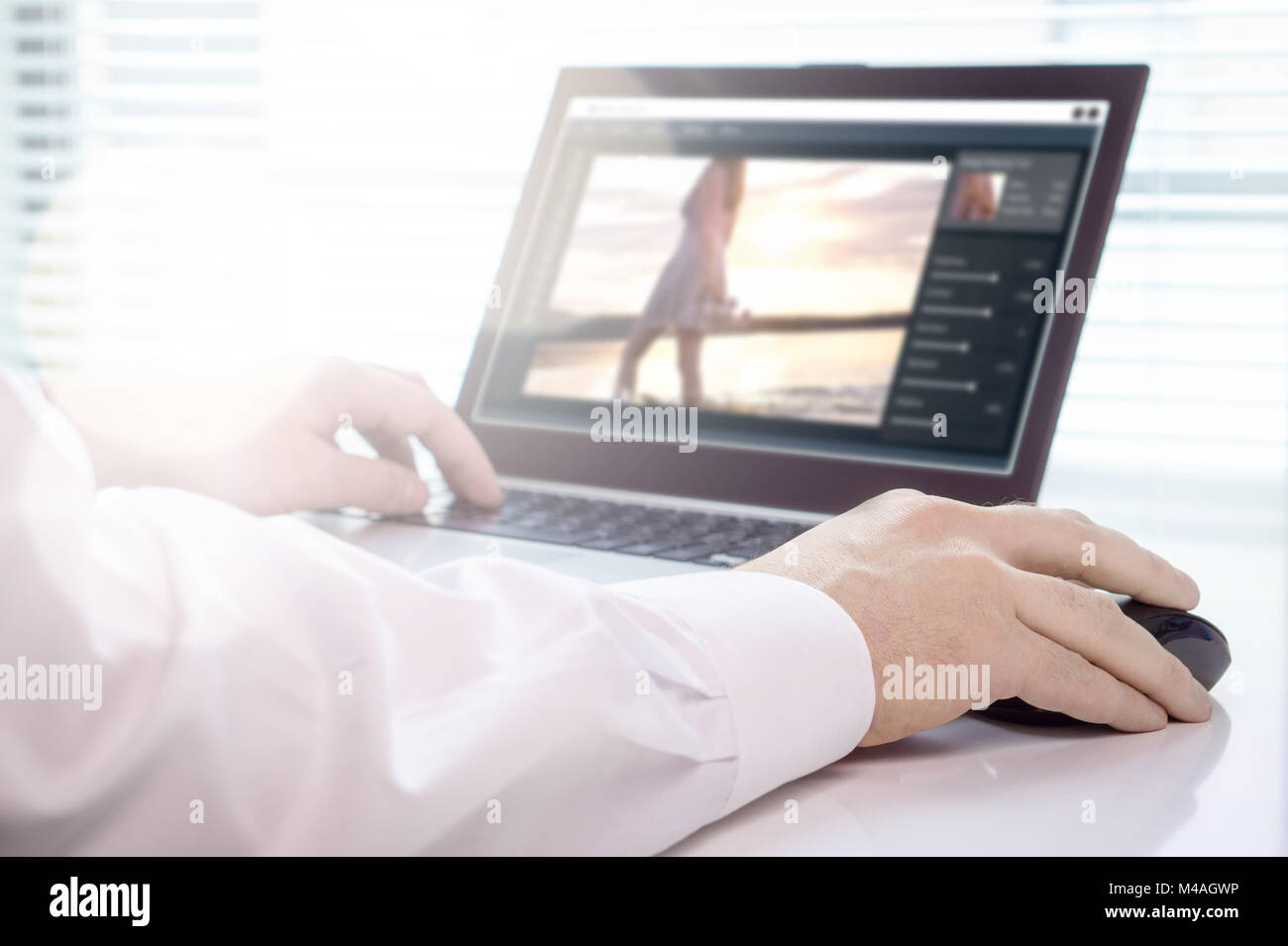 Édition de photos. Retouche d'une image de l'éditeur professionnel avec ordinateur portable et logiciel imaginaire. Travaillant en agence de création. Banque D'Images