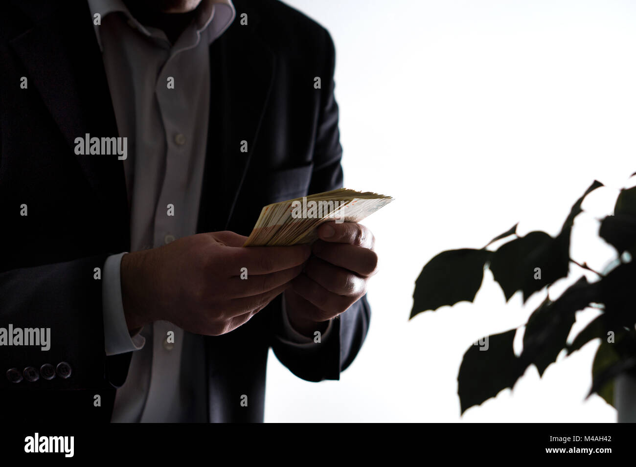 Blanchisserie de l'argent, la corruption et la cupidité concept. Homme d'homme en costume tenant une pile d'argent dans la main. Banque D'Images