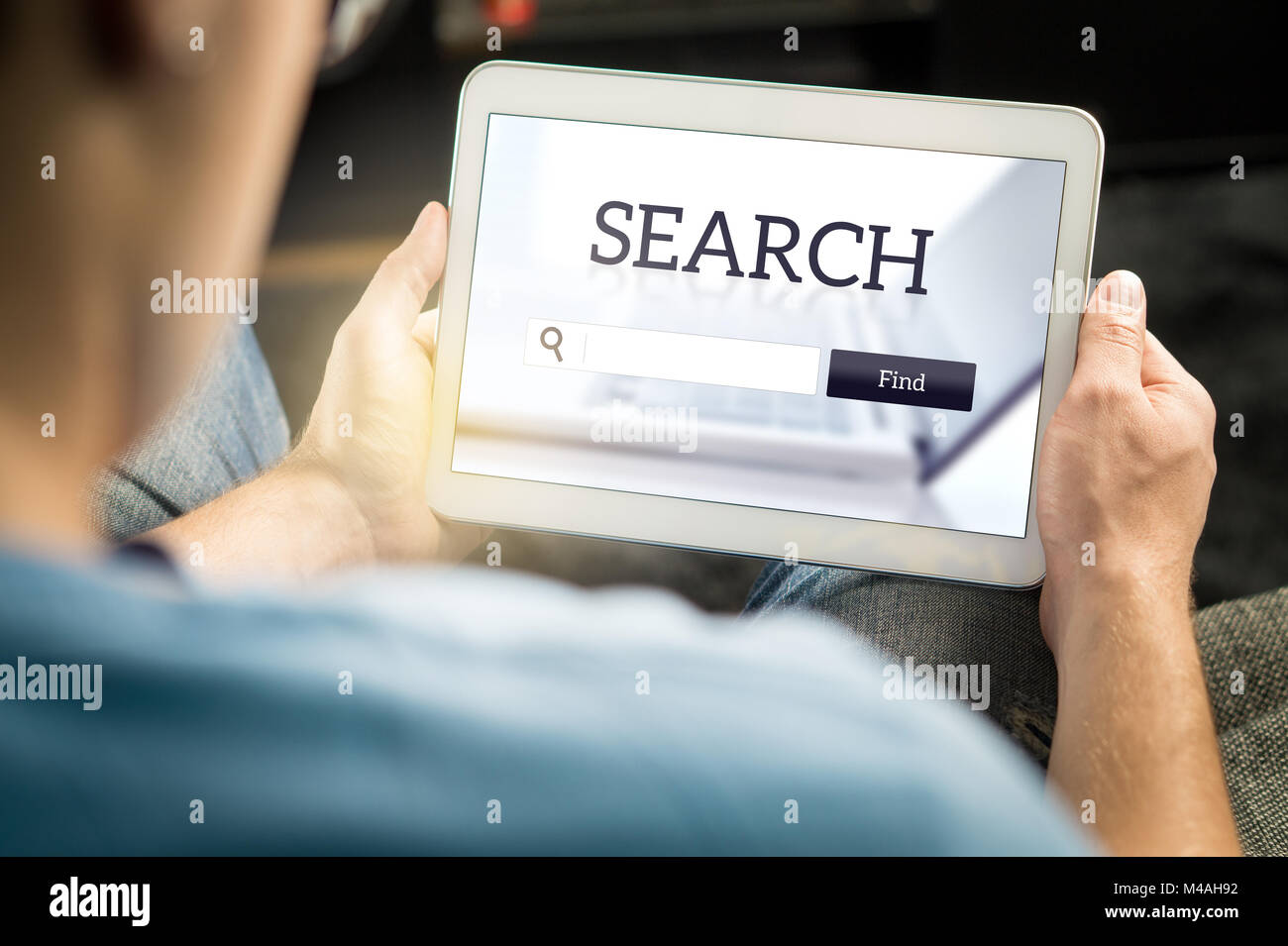 Moteur de recherche app sur écran de tablette. L'homme essaie de trouver site ou service de l'application de smart mobile device. Banque D'Images