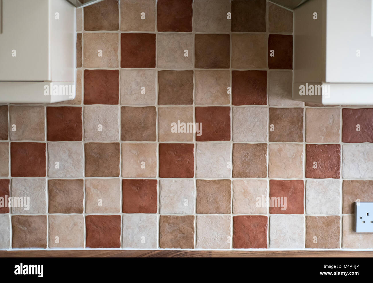 L'article d'une cuisine carrelée mur, au-dessus une plaque de cuisson avec des parties d'armoires de chaque côté. Banque D'Images