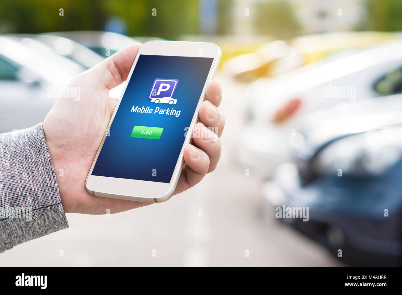 Parking Mobile app sur l'écran du smartphone. Man holding smart phone avec parking application dans la main. Le paiement en ligne sur Internet avec appareil moderne. Banque D'Images
