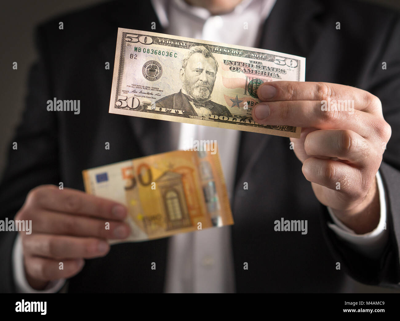 Dollar américain contre l'euro. Business man in suit holding 50 euros et le  projet de loi dans les deux monnaie dans la main. Taux de change, économie  mondiale et financière concept Photo