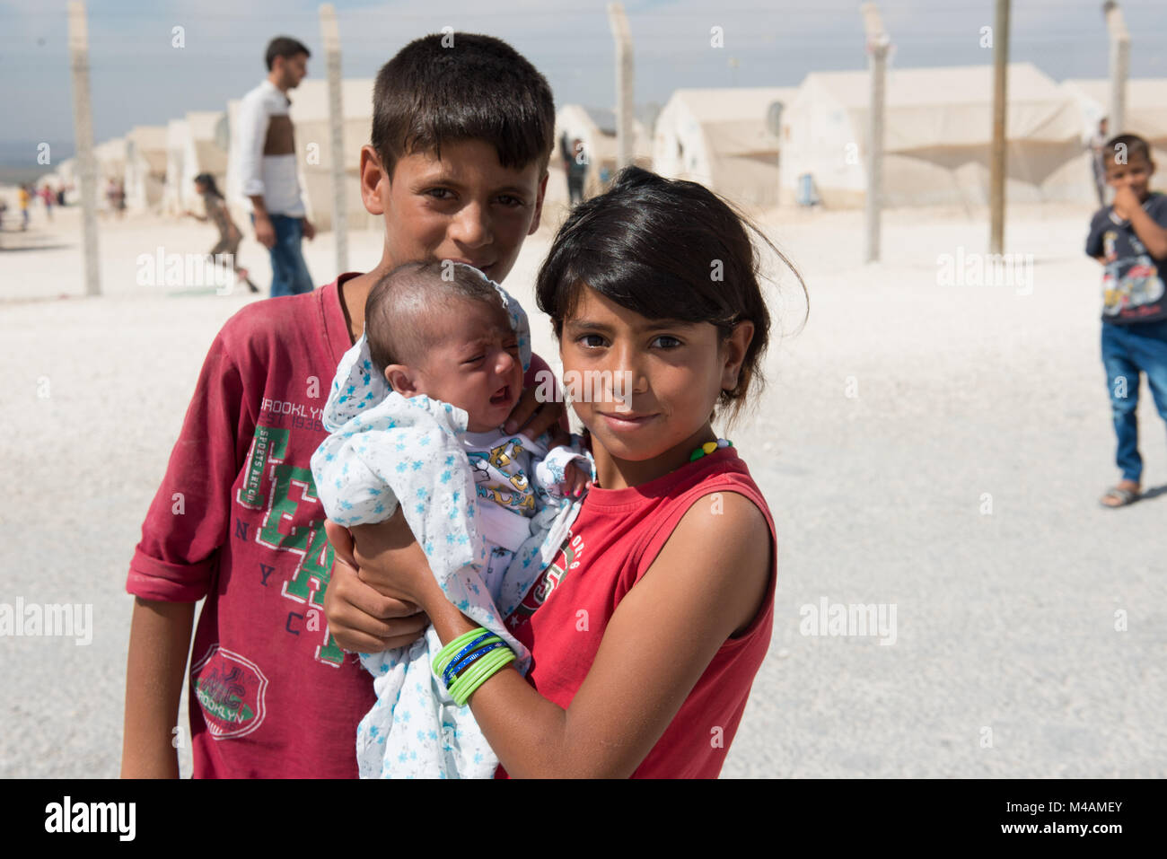 Un Garcon Et Une Fille Tenant Un Bebe Poser Dans Le Camp De Refugies De Suruc En Turquie Pres De La Frontiere Syrienne Photo Stock Alamy
