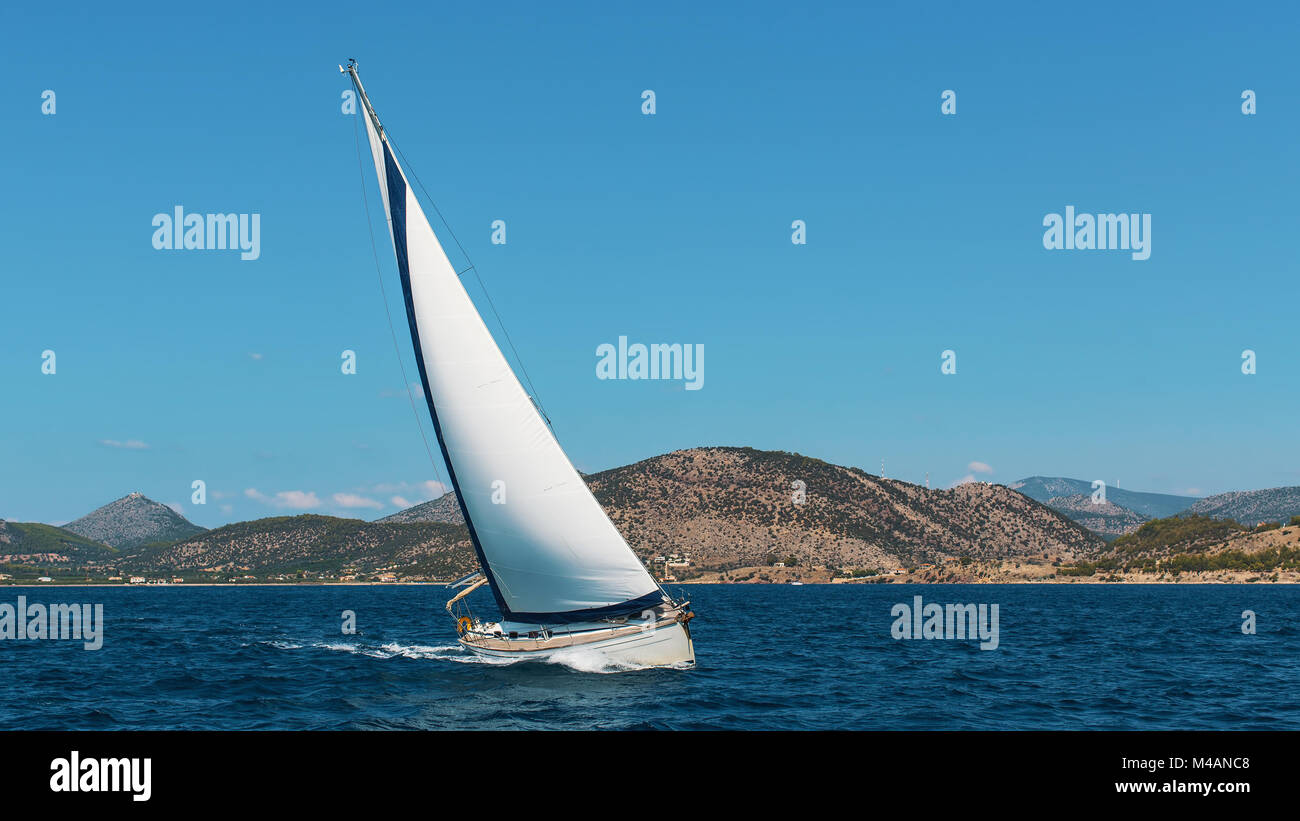 Location de bateau à voiles blanches dans la mer près des côtes des îles. Banque D'Images