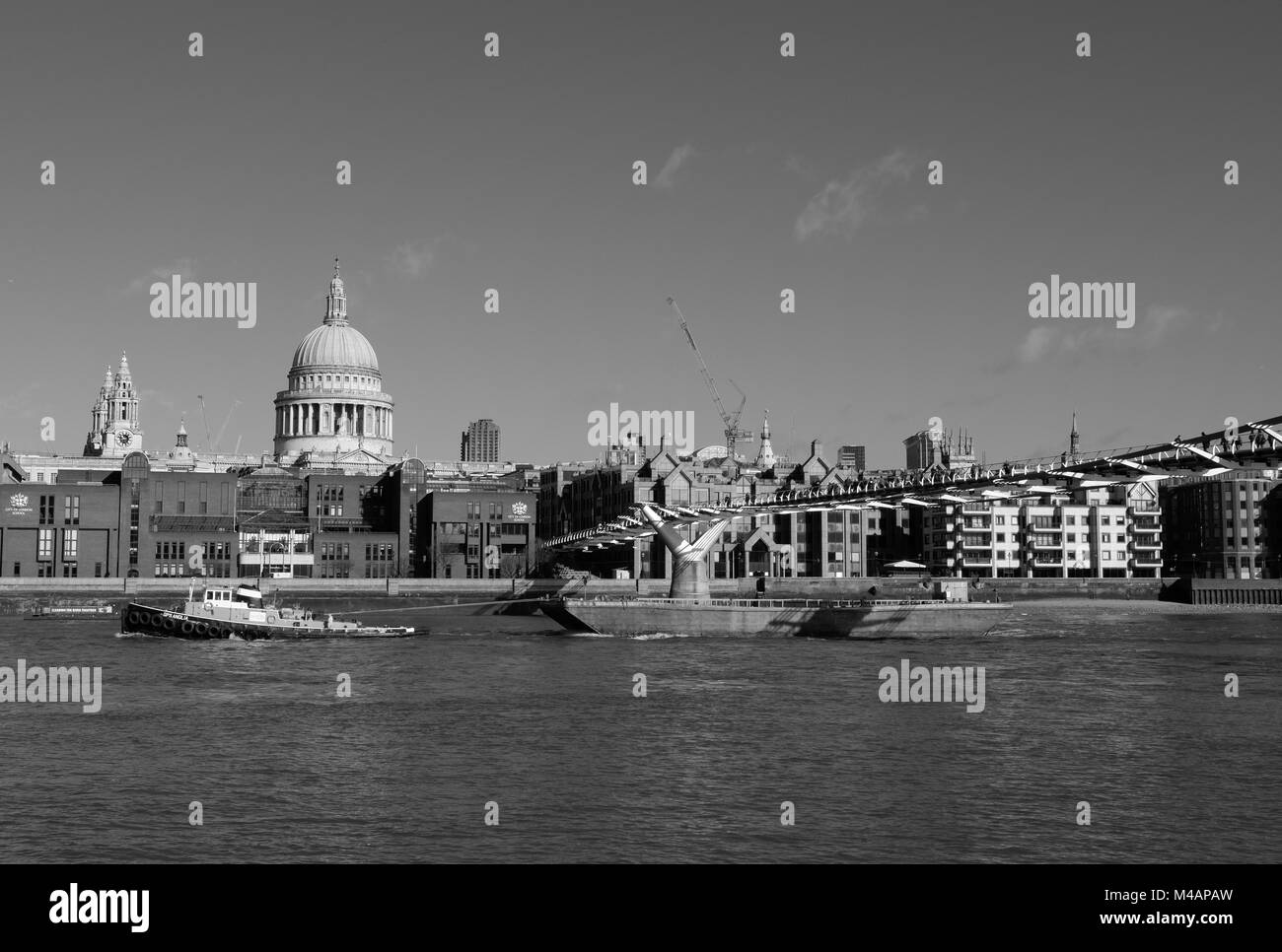 Bateau remorqueur chaland tirant le long de la rivière Thames, passant sous le pont du Millénaire, la Cathédrale St Paul en arrière-plan. Banque D'Images