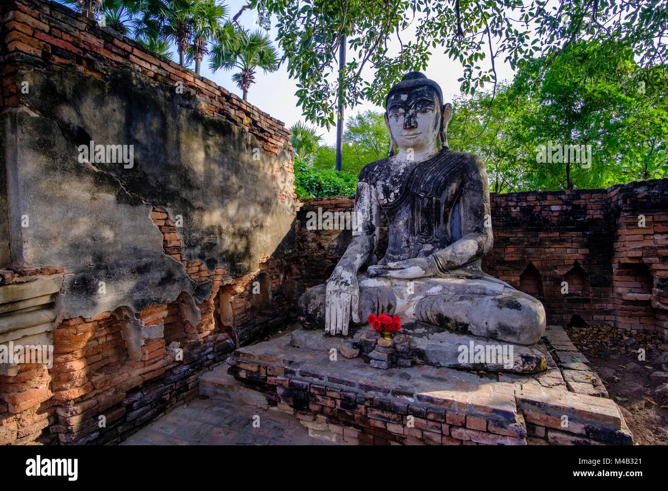 Une statue de bouddha est assis dans le bâtiments en brique de la Pagode Yadana Hsemee dans complexe Inwa, ancienne capitale de la Birmanie Banque D'Images