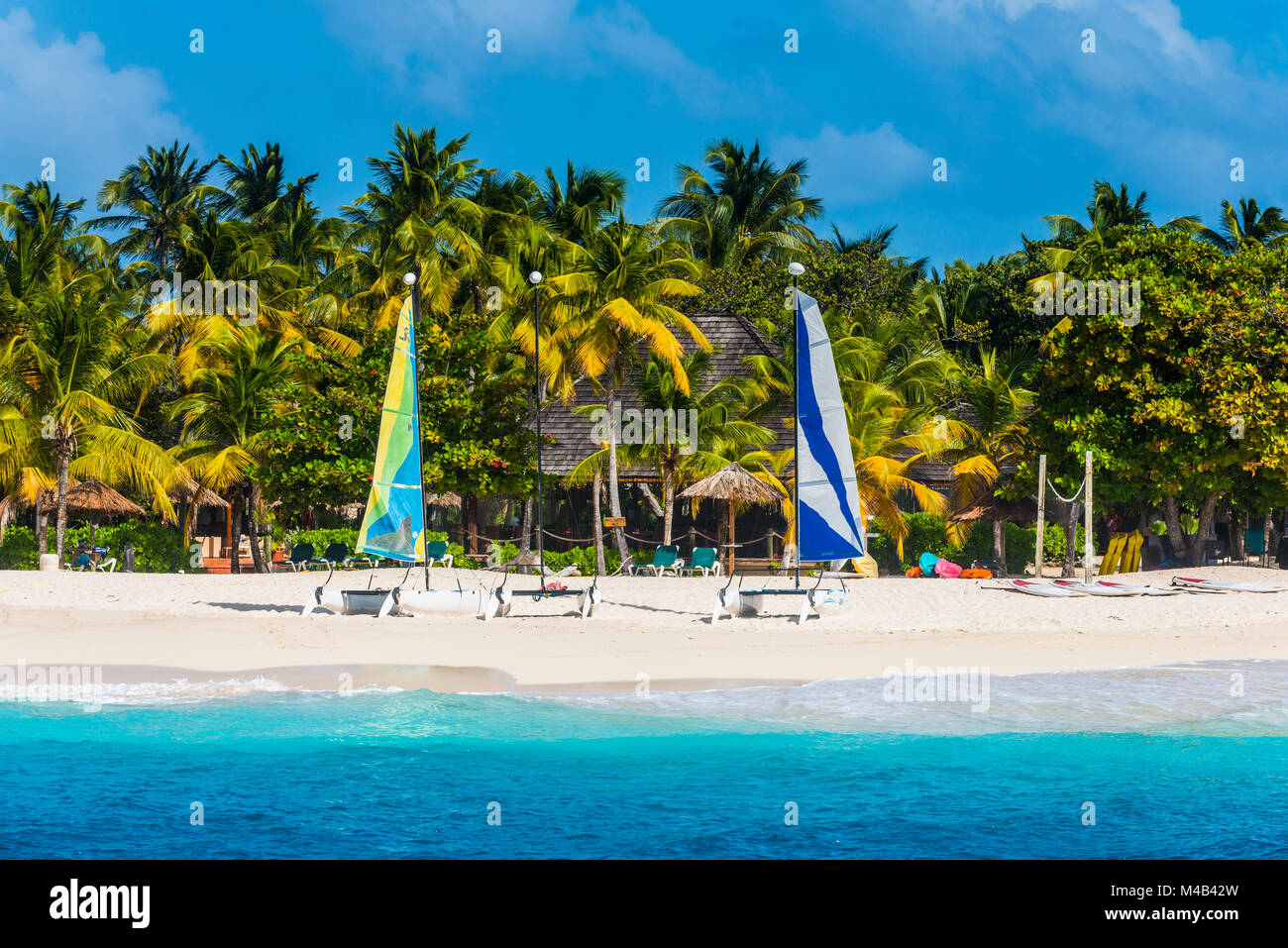 Catamarans sur une belle plage de sable blanc bordée de cocotiers sur Palm Island, îles Grenadines,St. Vincent et les Grenadines,Caraïbes Banque D'Images