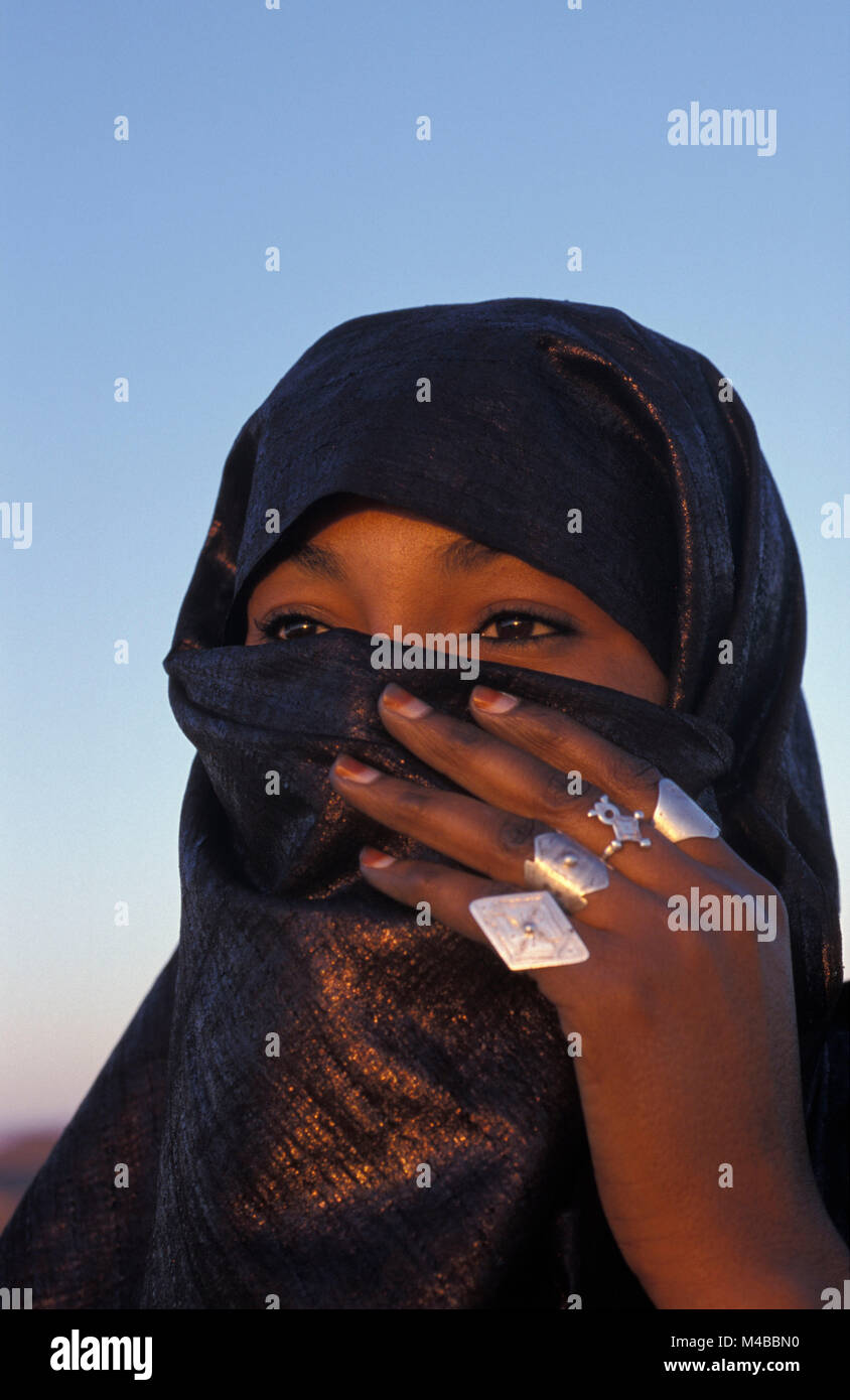 L'Algérie. Près de Djanet. Désert du Sahara. Femme voilée de tribu touareg.  Foulard bleu indigo. Bagues argent. Portrait Photo Stock - Alamy