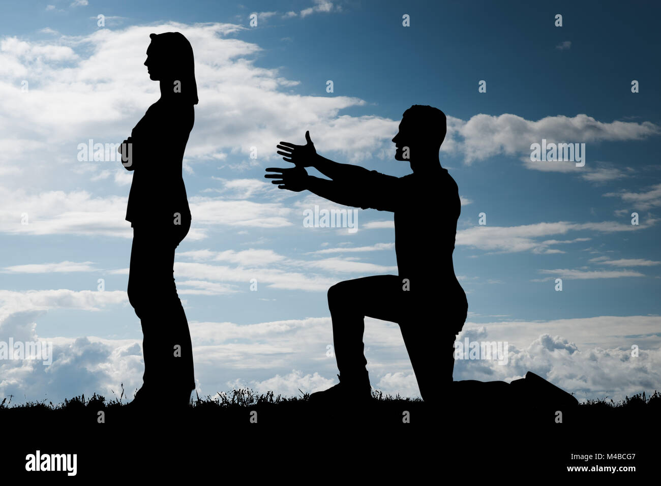 Silhouette d'un homme qui tente de convaincre sa petite amie Banque D'Images