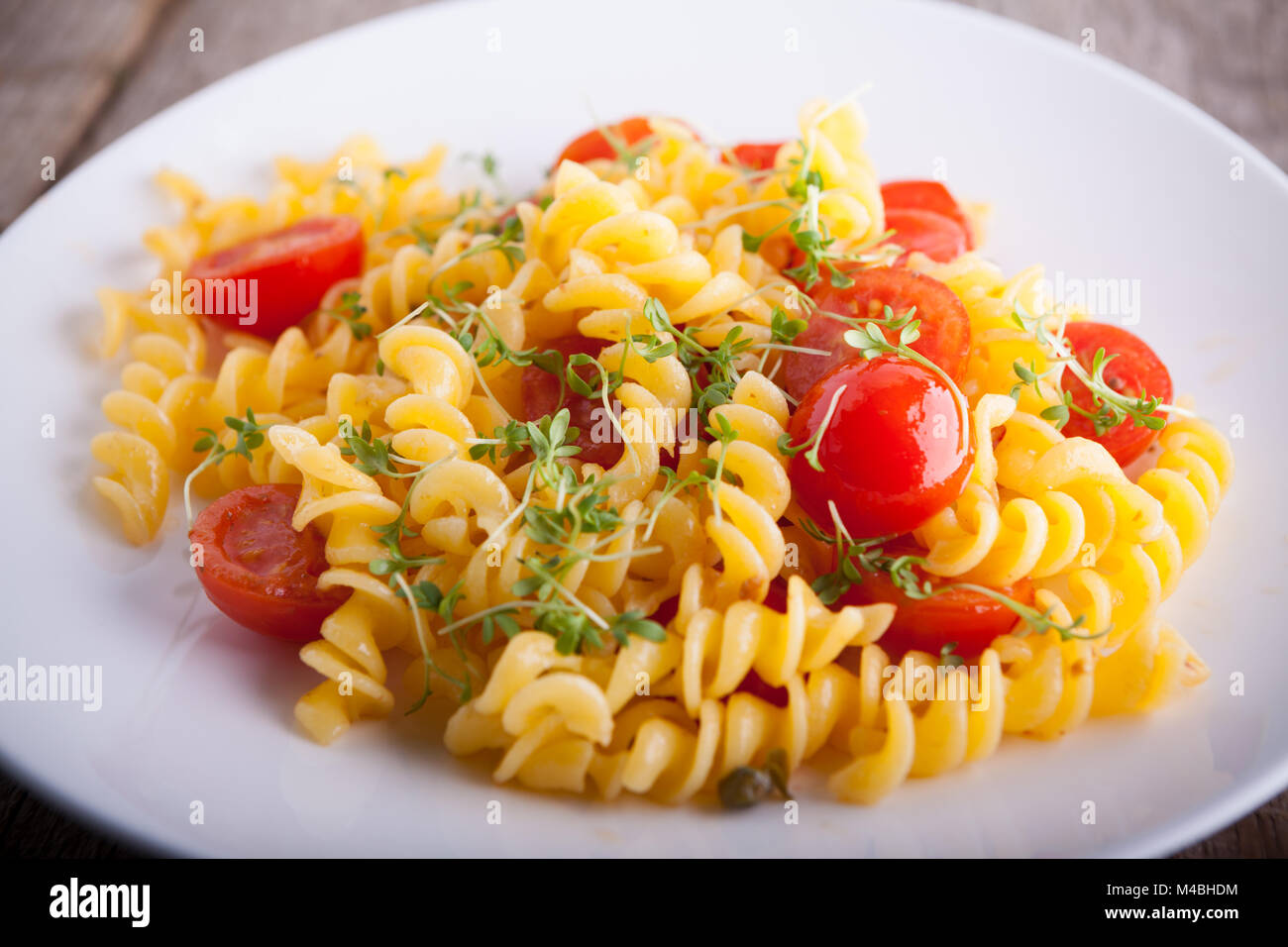 Fussili pâtes avec le cresson et tomates cerises. Banque D'Images