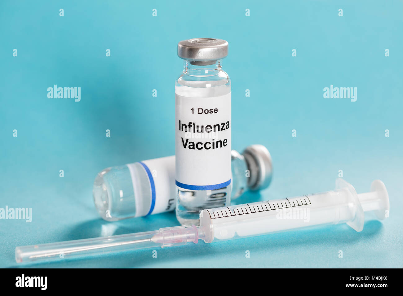 Les flacons de vaccin contre la grippe La grippe avec la seringue sur fond bleu turquoise Banque D'Images