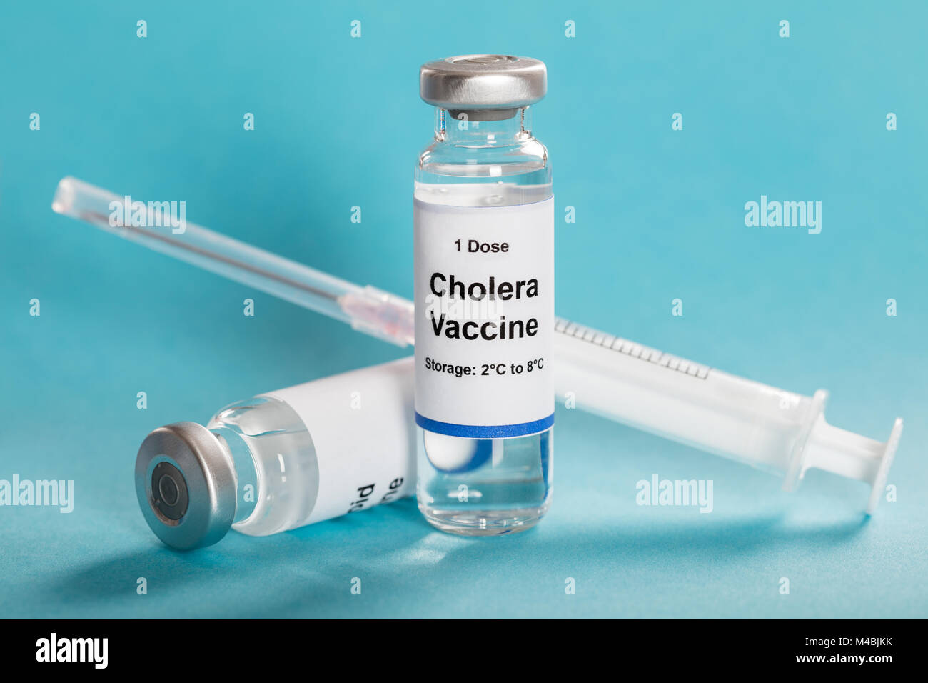 Une dose de vaccin contre le choléra en flacon avec seringue sur fond bleu turquoise Banque D'Images