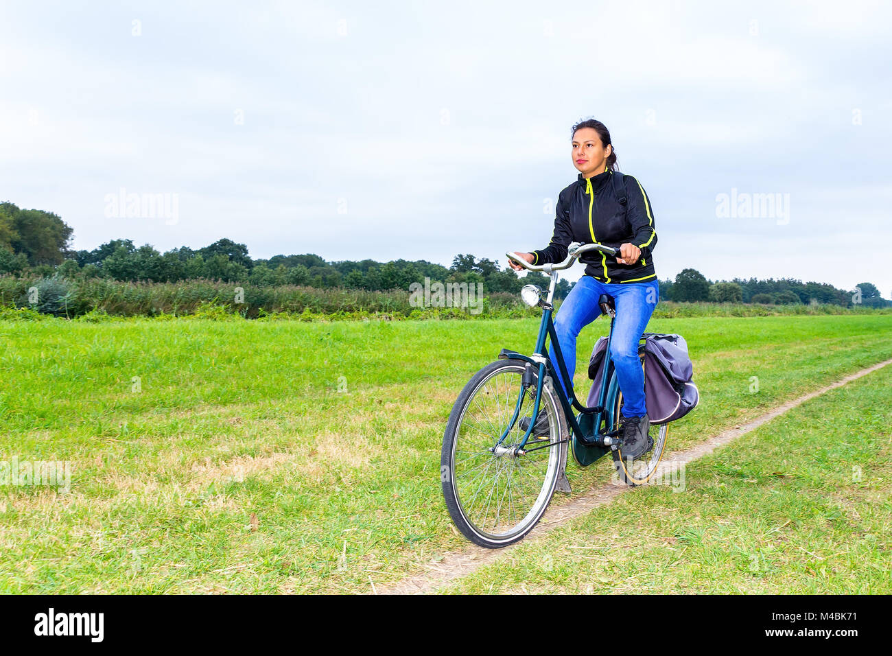 Vélo femme colombienne sur le chemin en néerlandais nature paysage Banque D'Images