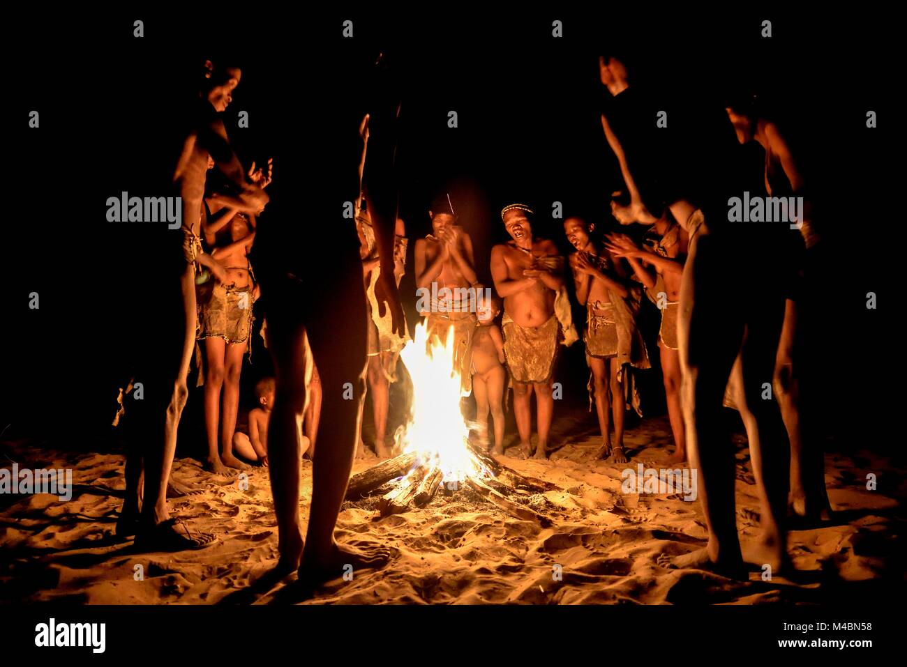 Les bushmen de Ju/" Hoansi-San stand par le feu de camp,village //Xa/oba,près de Tsumkwe Otjozondjupa,région,Namibie Banque D'Images