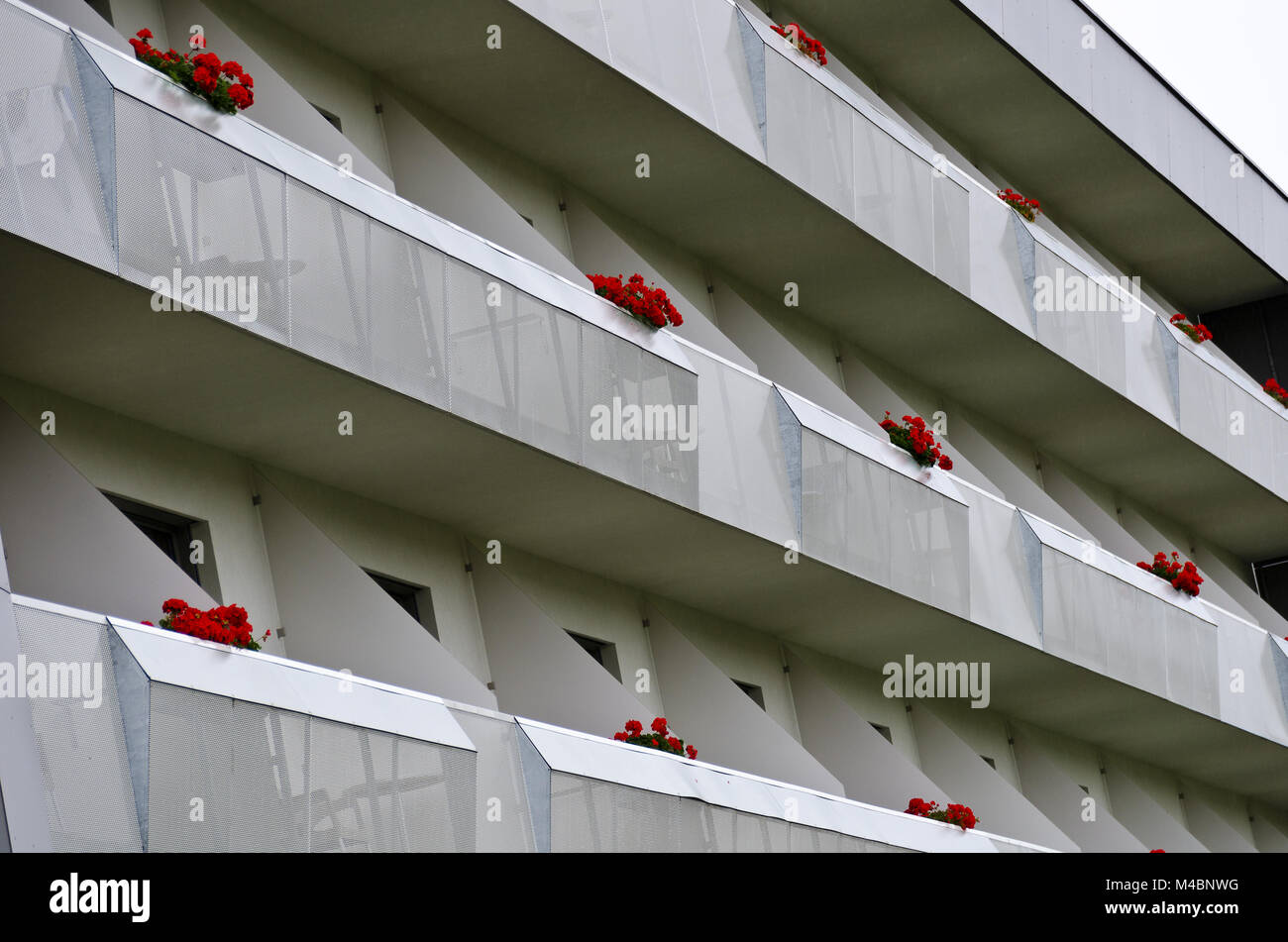 Avant en aluminium gris d'un hôtel avec balcon rouge fleurs Banque D'Images