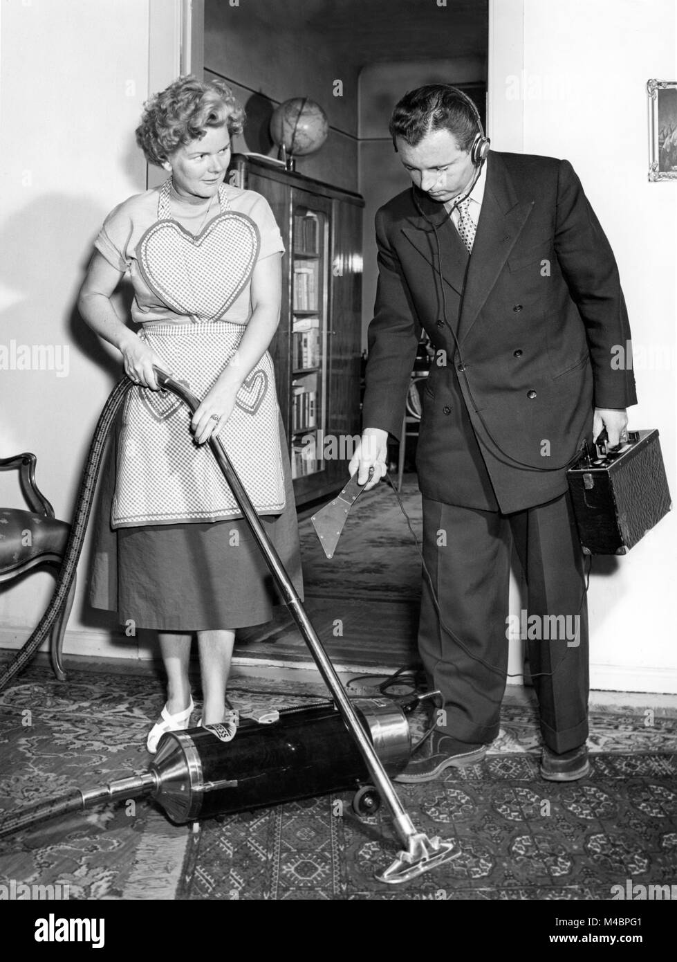 Représentant et femme au foyer avec l'aspirateur,homme mesurant le bruit,1950,emplacement exact inconnu,Allemagne Banque D'Images