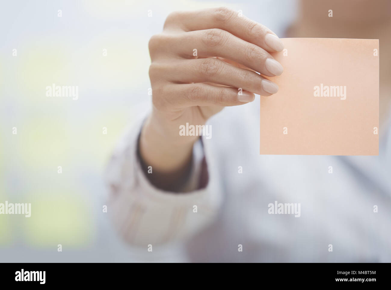 Main de femme tenant sticky note avec l'espace vide Banque D'Images