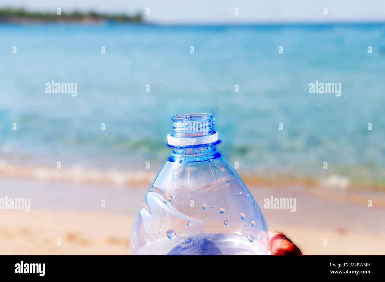 Bouteille Pet Avec De Leau Sur La Mer Avec Hand Holding
