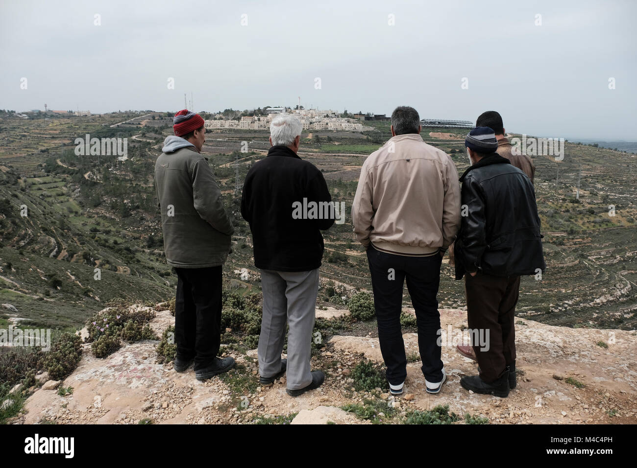 Les propriétaires fonciers palestiniens qui revendiquent leurs terres prises par des colons juifs contemplant la colonie israélienne de Rosh Tzurim en Cisjordanie Israël Banque D'Images