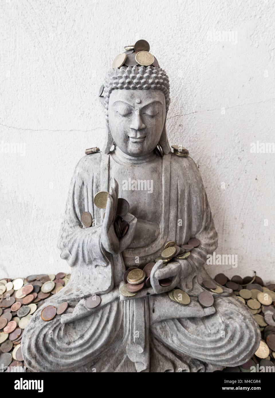 Statue de Bouddha avec des pièces comme offrant Banque D'Images