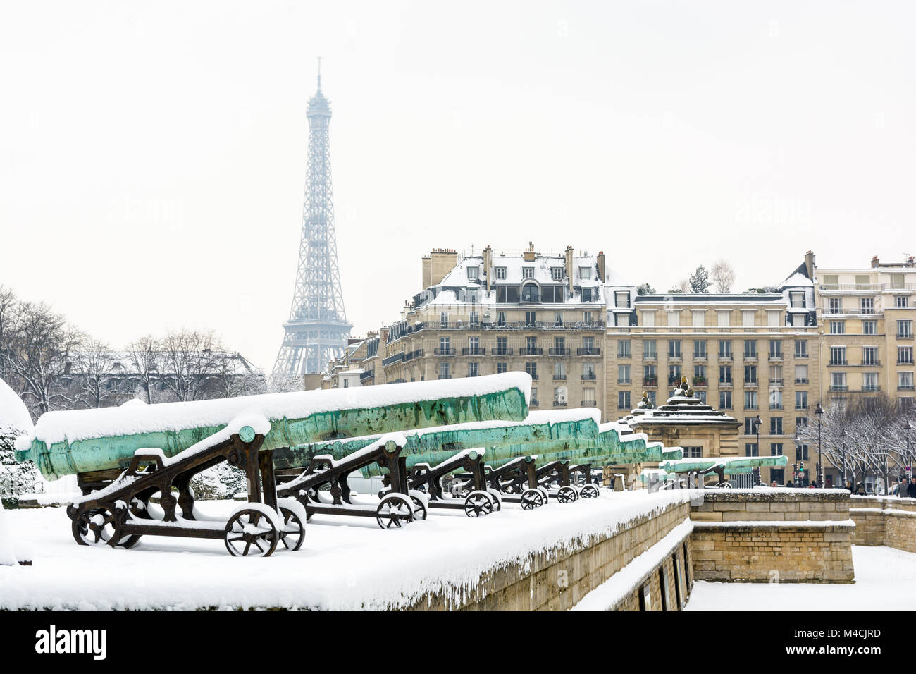 L'hiver à Paris dans la neige. La rangée de canons en bronze de la Place des Invalides avec un immeuble parisien et la Tour Eiffel en arrière-plan. Banque D'Images L'hiver à Paris dans la neige. La rangée de canons en bronze de la Place des Invalides avec un immeuble parisien et la Tour Eiffel en arrière-plan. Banque D'Images
