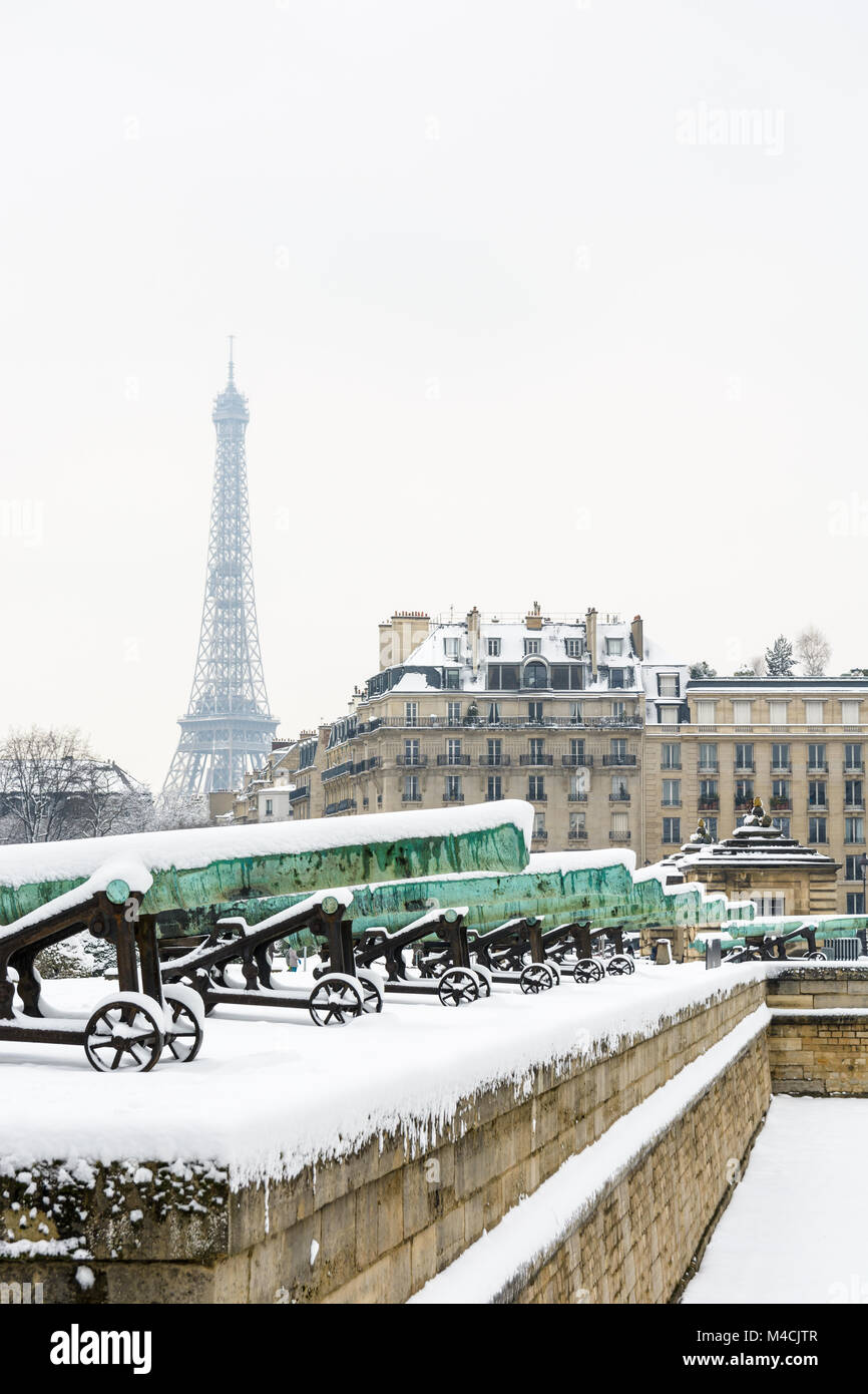L'hiver à Paris dans la neige. La rangée de canons en bronze de la Place des Invalides avec un immeuble parisien et la Tour Eiffel en arrière-plan. Banque D'Images L'hiver à Paris dans la neige. La rangée de canons en bronze de la Place des Invalides avec un immeuble parisien et la Tour Eiffel en arrière-plan. Banque D'Images