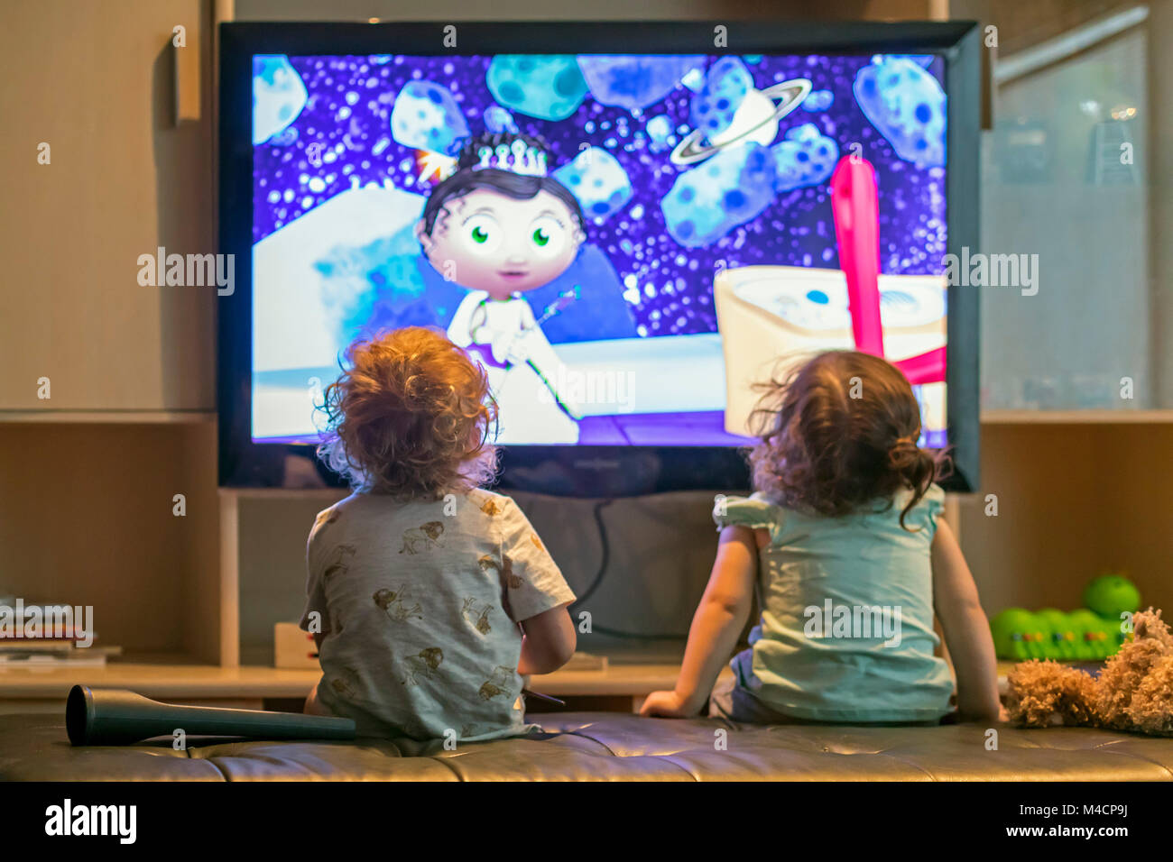 Enfants d'âge pré-scolaire regarder dessins animés à la télévision. Banque D'Images