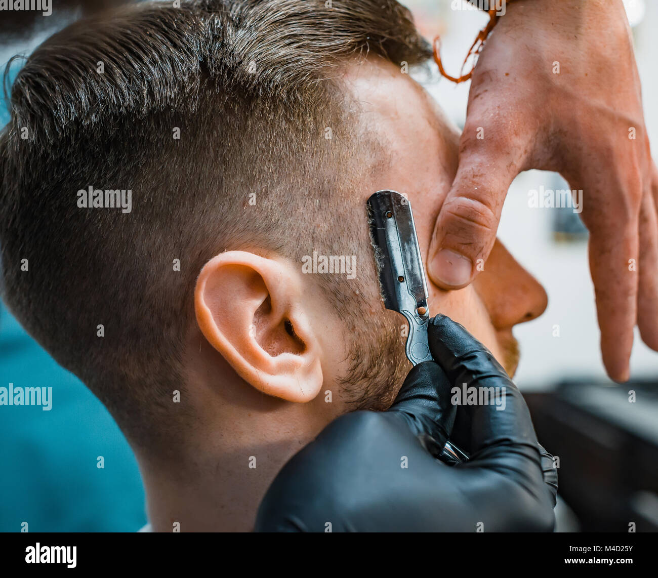 La forme idéale de la barbe et les coupes de cheveux dans un salon de  barbier. Salon de coiffure à penser le contour avec un rasoir. Soins du  corps des hommes. Soft