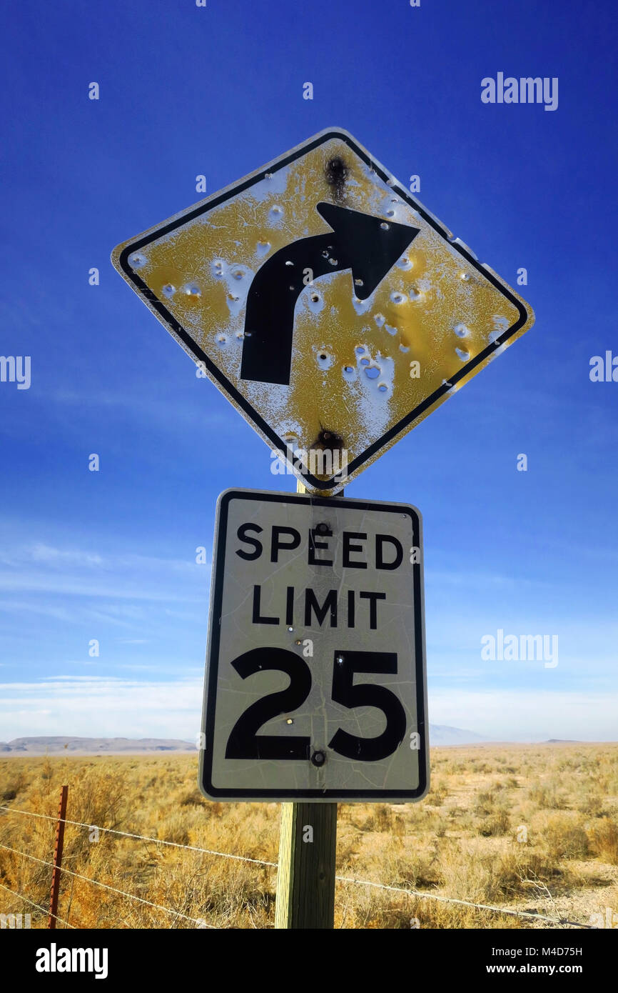 Battre un signe sur une limite de vitesse dans le bleu clair plaine désertique. Banque D'Images