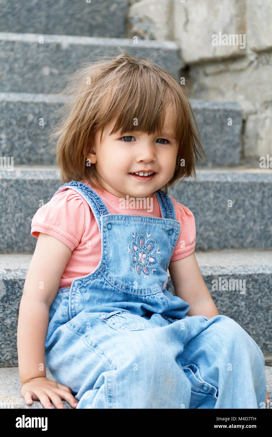 Baby Girl sitting on l'escalier en pierre Banque D'Images