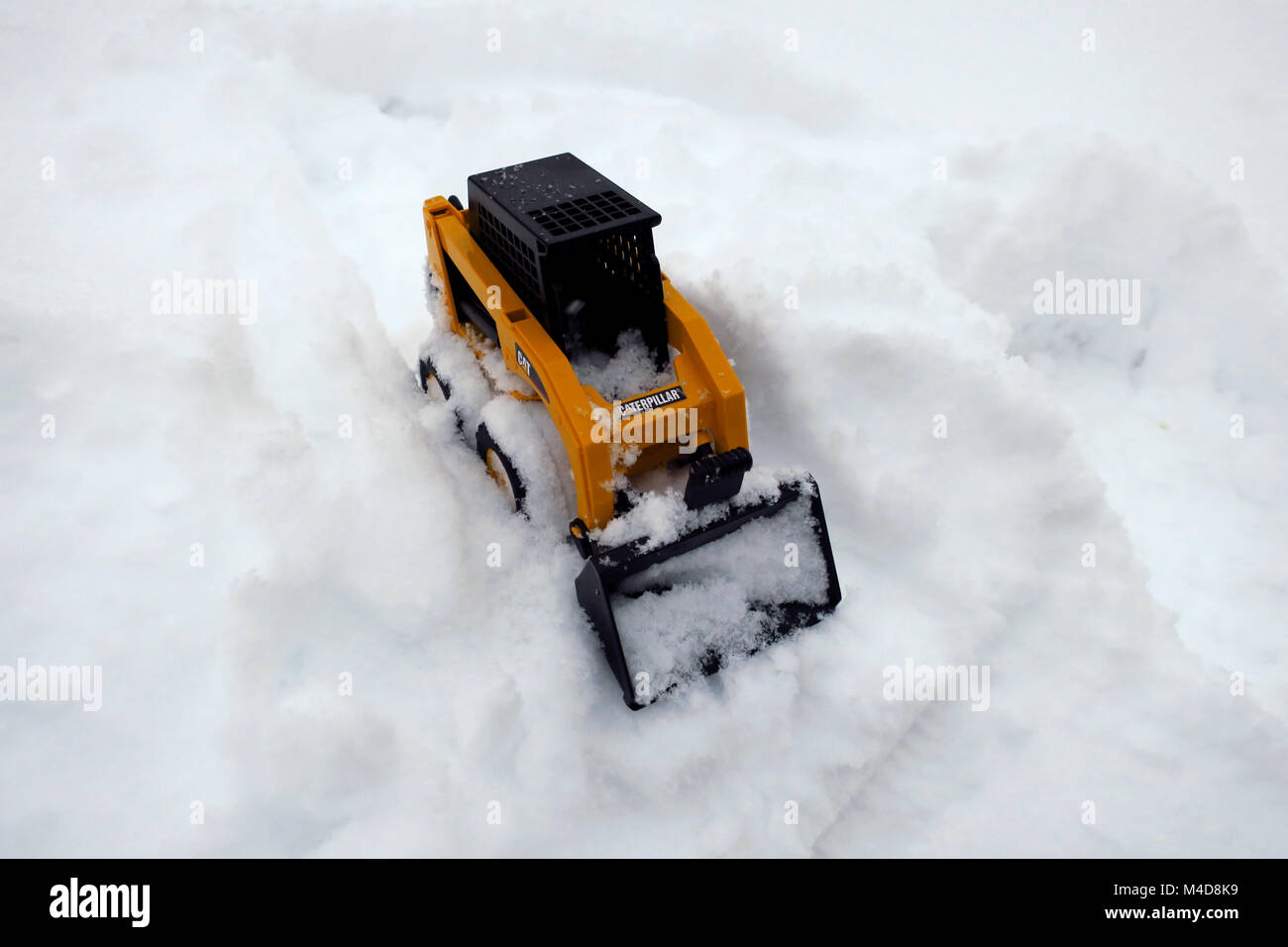 Un petit jouet jaune loader le mouvement de la neige. Concept Banque D'Images