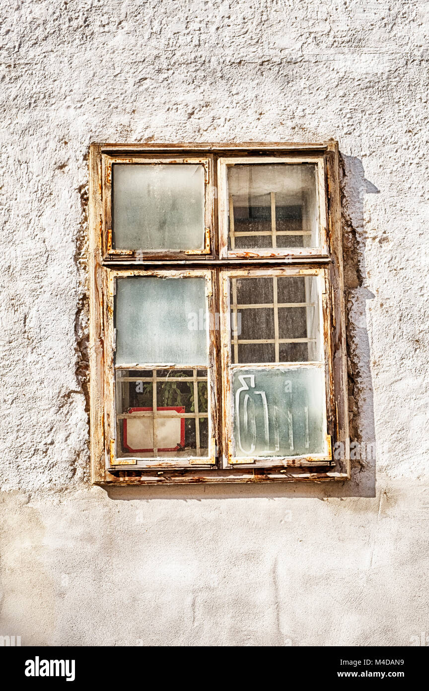 Une ancienne fenêtre avec volets en partie de la buée est au milieu d'un mur blanc dans la vieille ville de Bratislava, Slovaquie. Banque D'Images