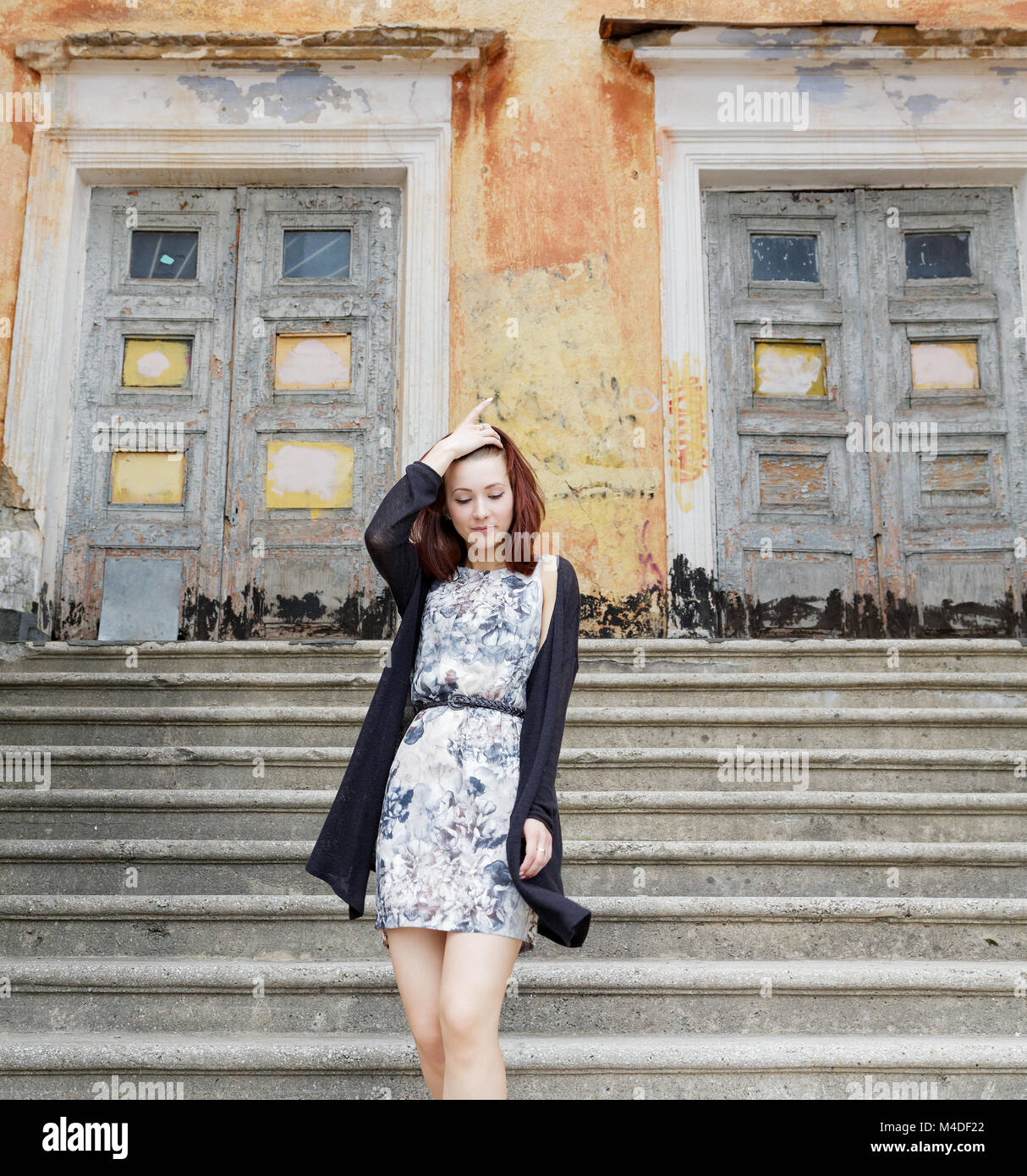 Fille en robe sur les marches d'un vieux bâtiment Banque D'Images