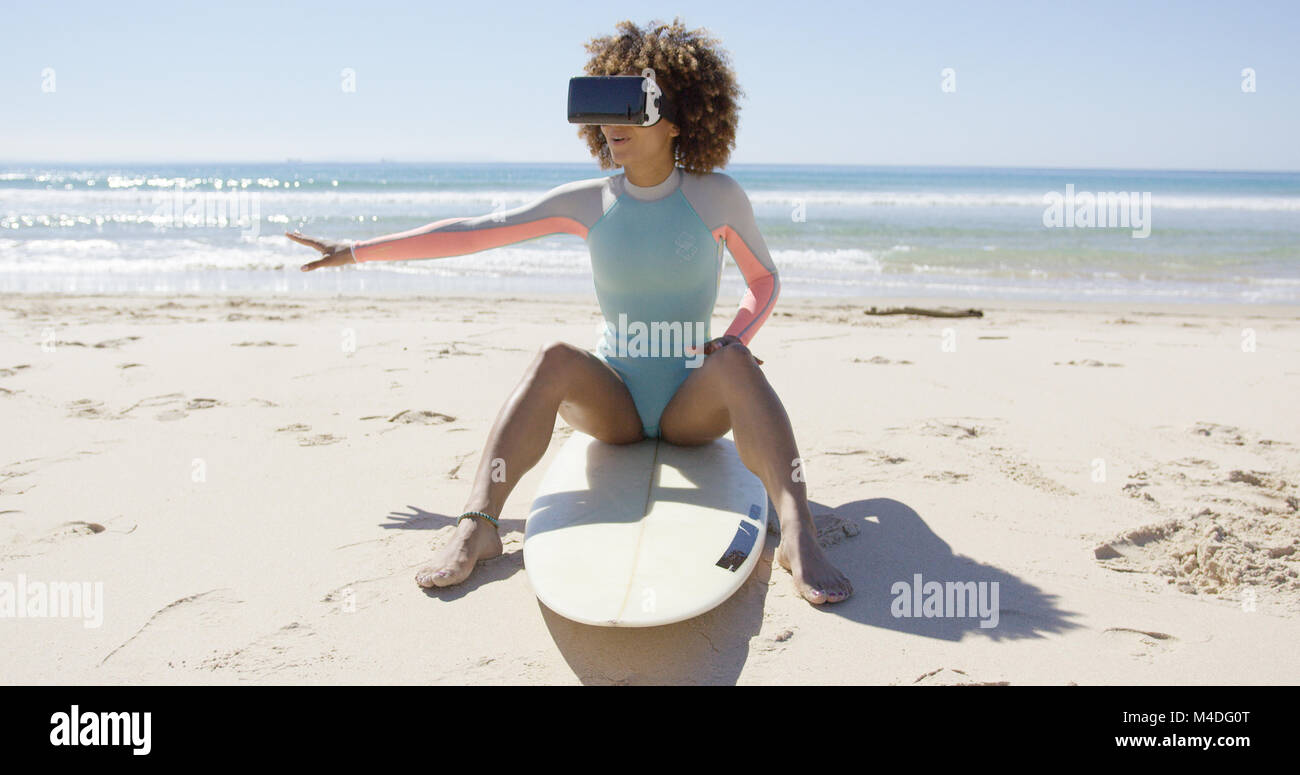 Femme portant des lunettes de réalité virtuelle sur la plage Banque D'Images