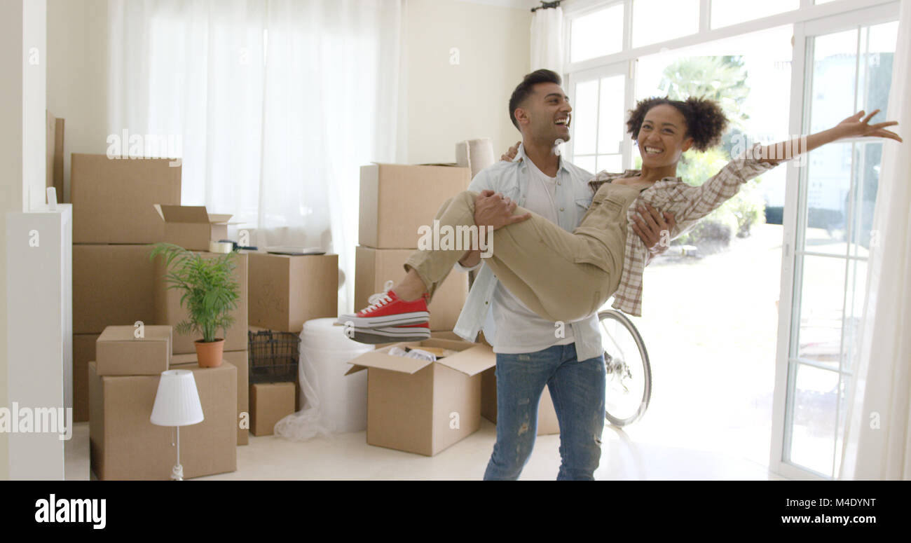 Jeune couple extatique à célébrer leur nouvelle maison Banque D'Images