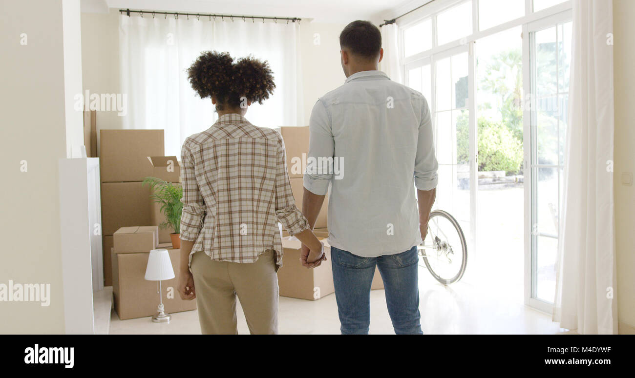 Jeune couple aimant de dire au revoir à leur maison Banque D'Images