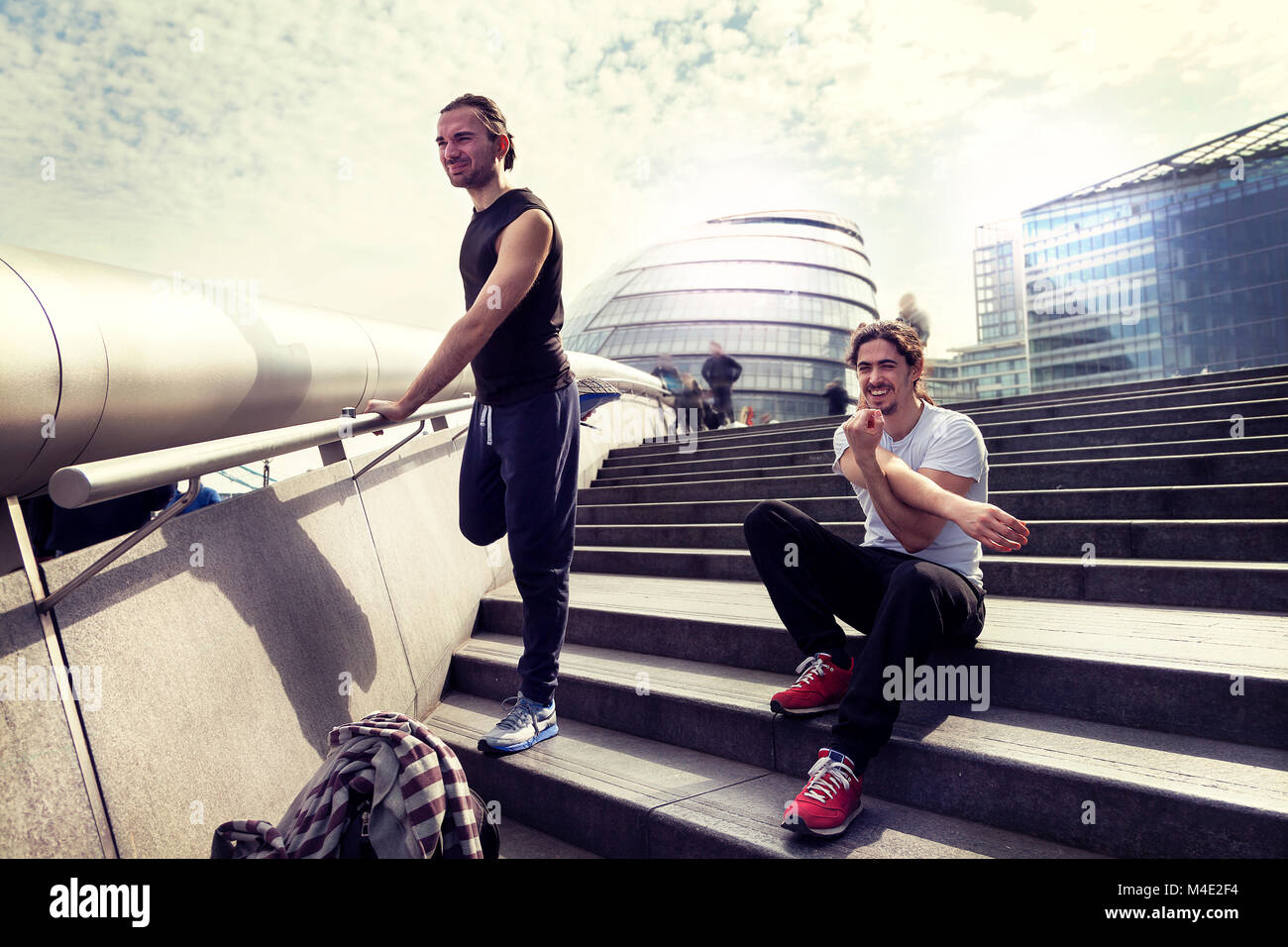 Les jeunes adultes sont athlétique qui s'étend en face de l'hôtel de ville de Londres Banque D'Images