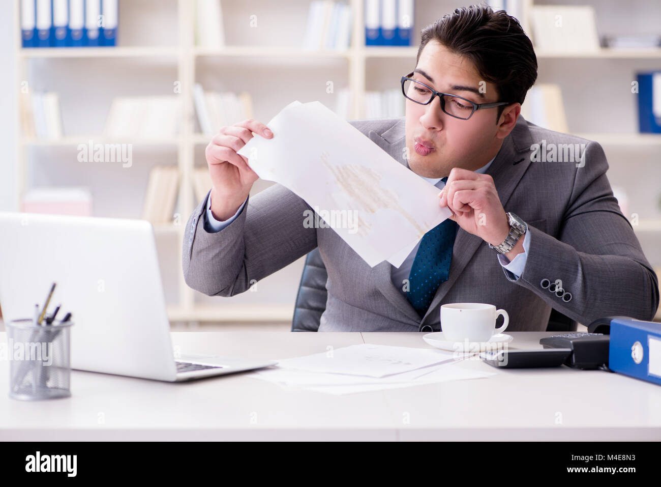 Businessman de renverser du café sur des documents importants Banque D'Images Businessman de renverser du café sur des documents importants Banque D'Images