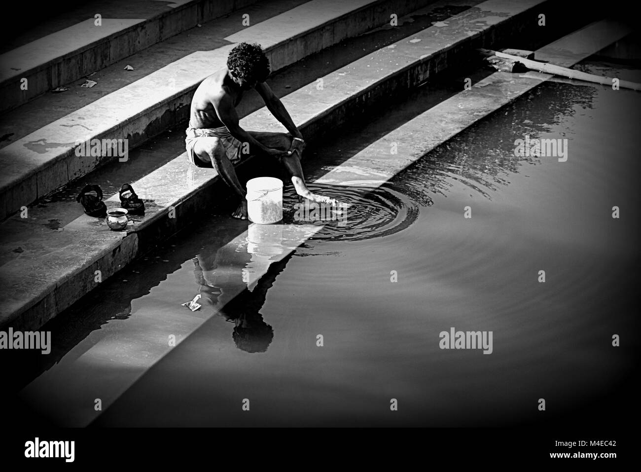 Un homme echelle sur le Ganga Ghat, Varanasi, Inde. Banque D'Images