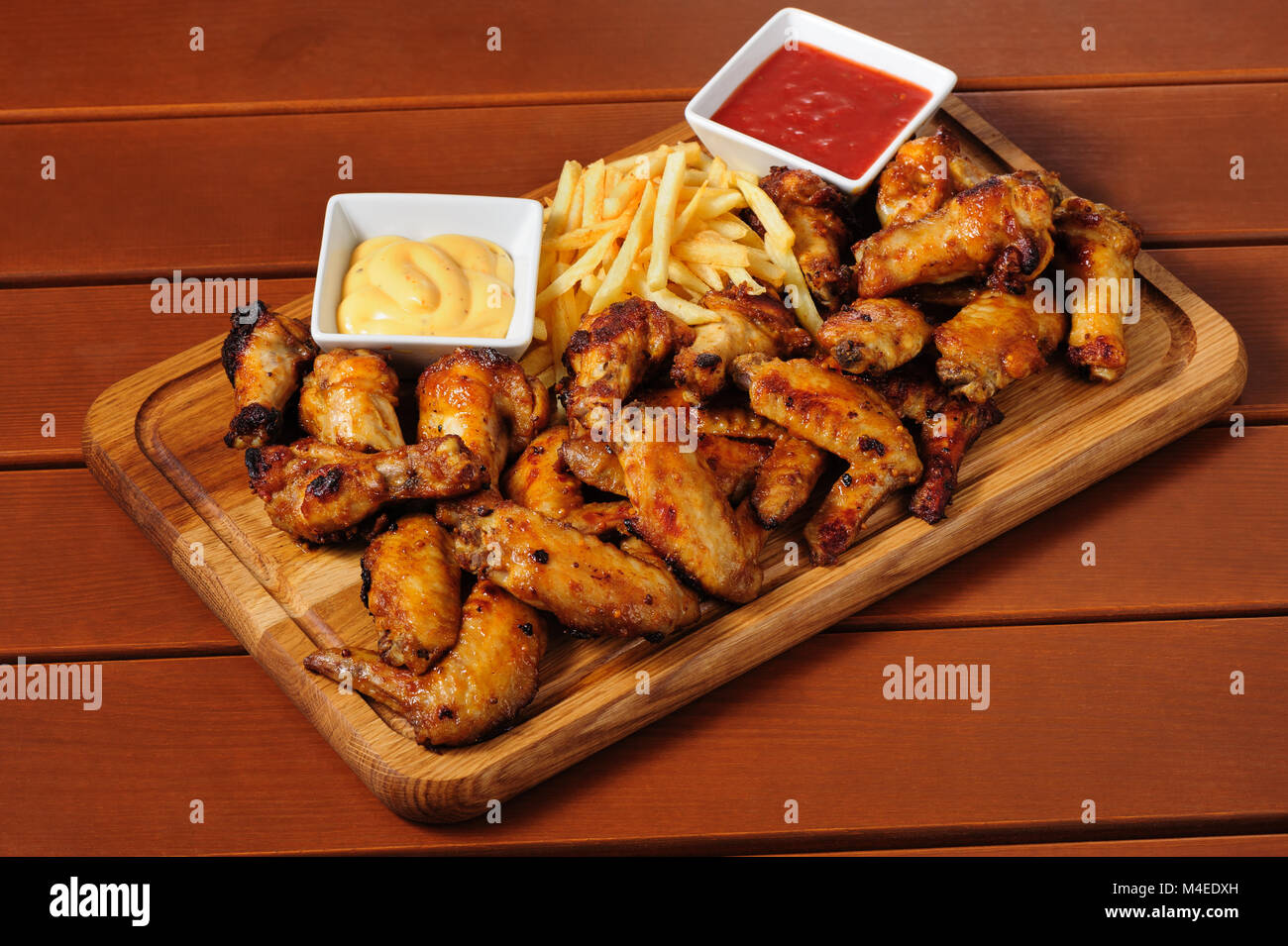 Grande planche en bois avec des vents au poulet grillé Banque D'Images
