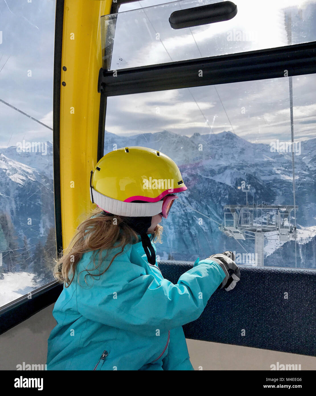 Fille assise dans un télésiège, Alpes, Braunwald, Suisse Banque D'Images