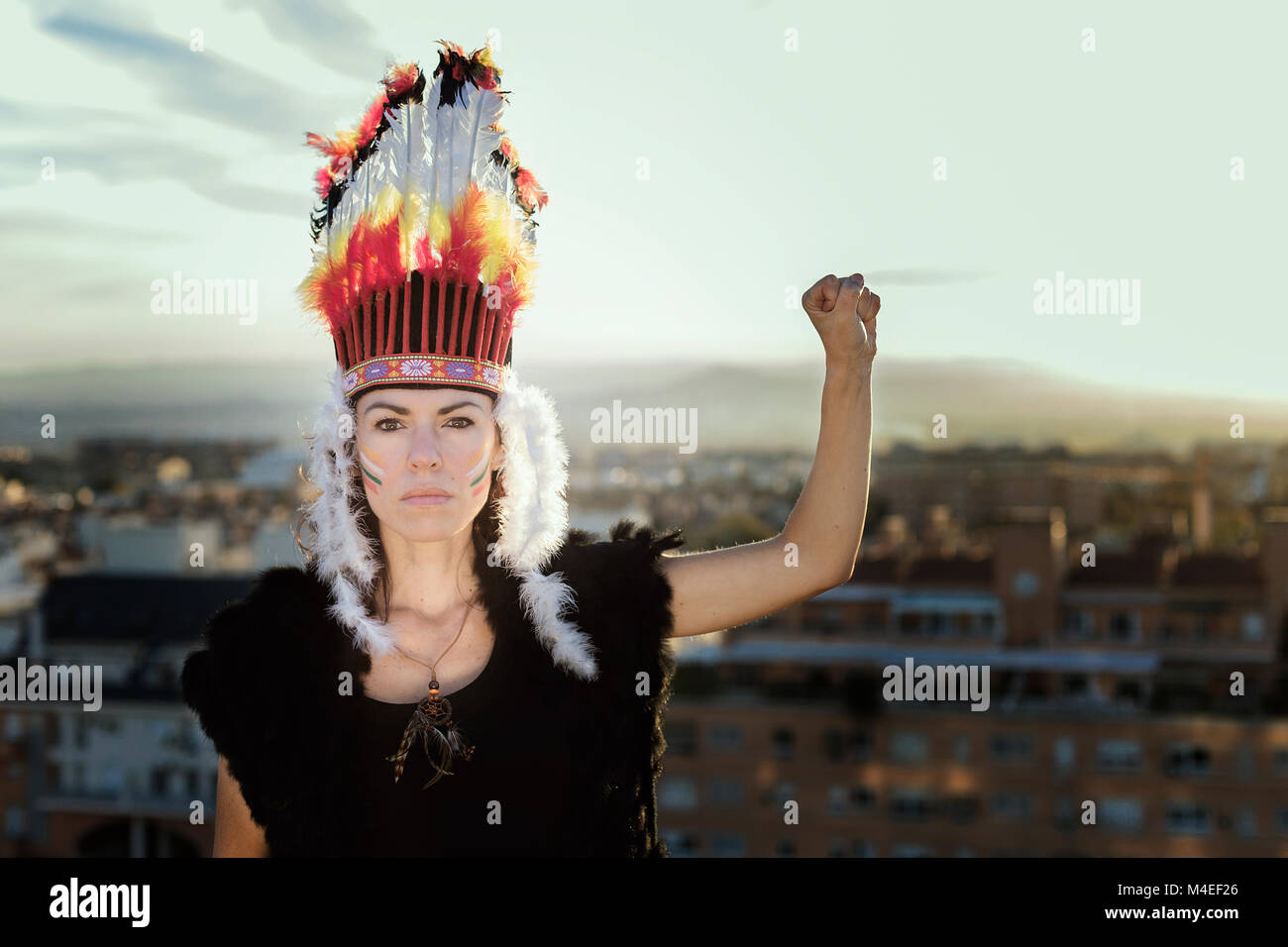 Portrait d'une femme portant une plume de headaddress tenant son poing dans les airs, Grenade, Andalousie, Espagne Banque D'Images
