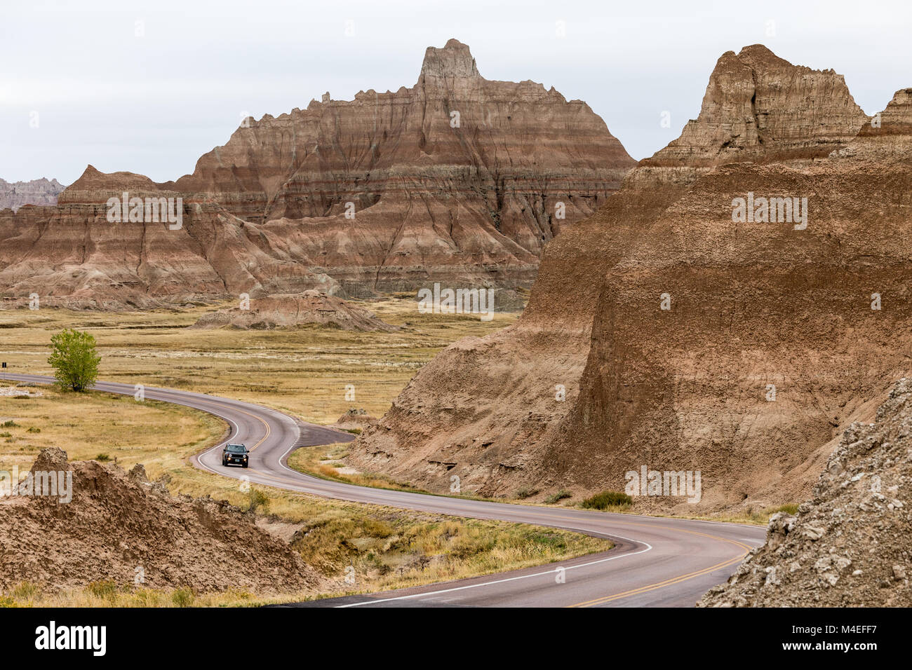 Voiture en voiture le long de la route sinueuse, parc national de Badlands, Dakota du Sud, États-Unis Banque D'Images